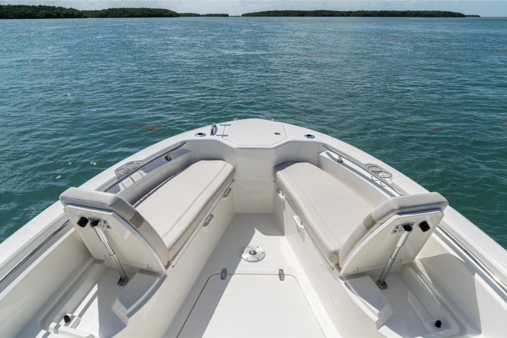 2024 Boston Whaler 280 Dauntless boat interior with cushioned seating on calm water.