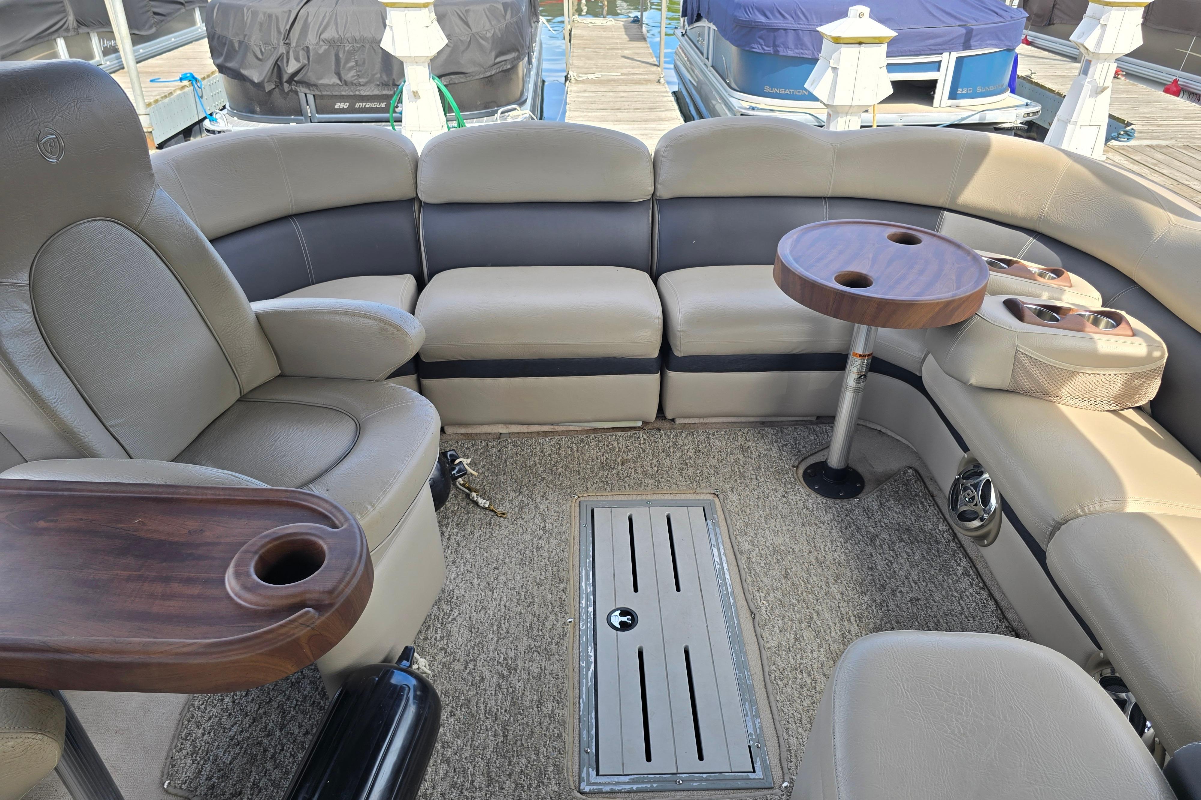 Interior of a 2013 Premier 275 Boundary Waters pontoon boat with plush seating and tables.