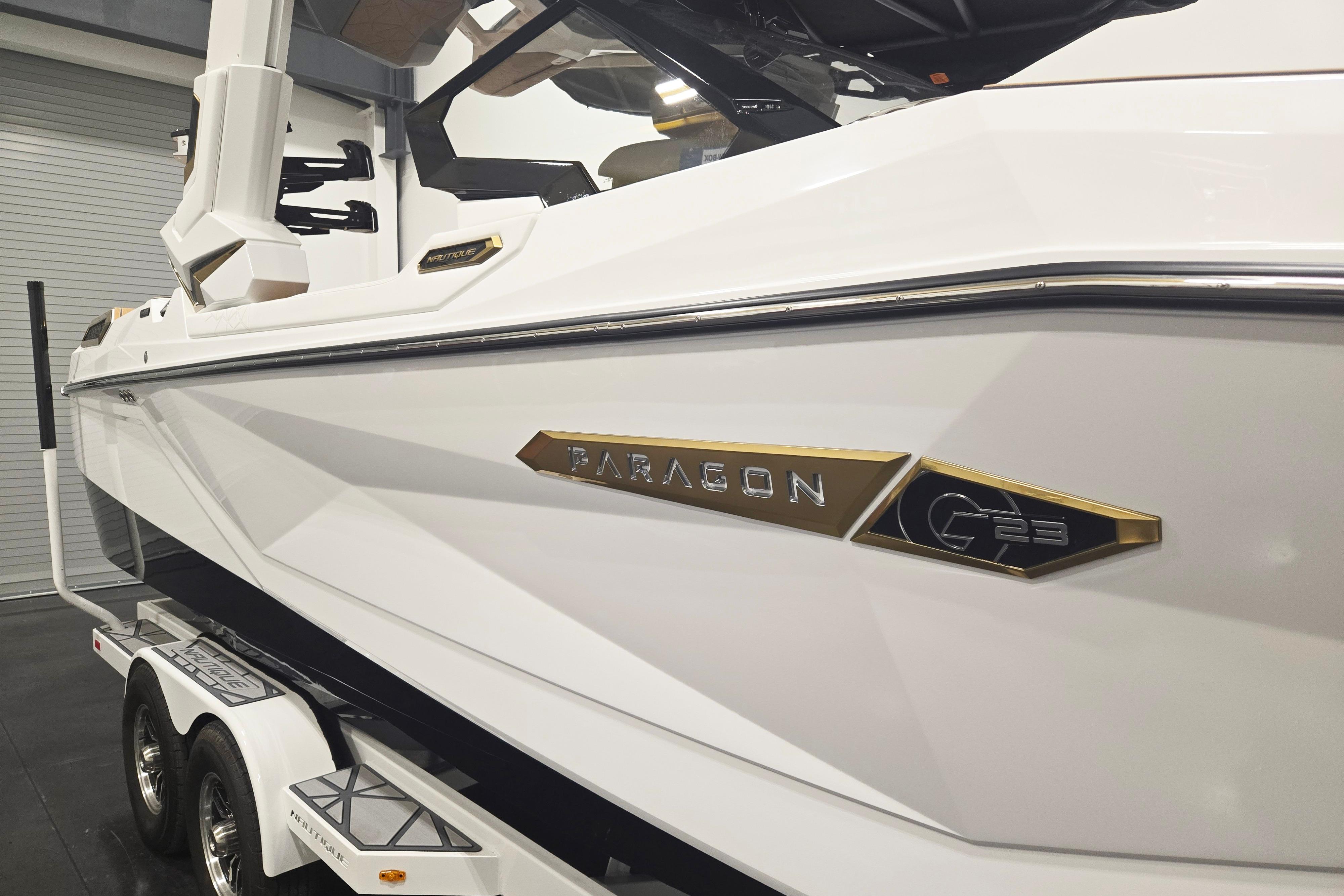 2026 Nautique Super Air Nautique G23 Paragon boat, white exterior, on trailer in showroom.