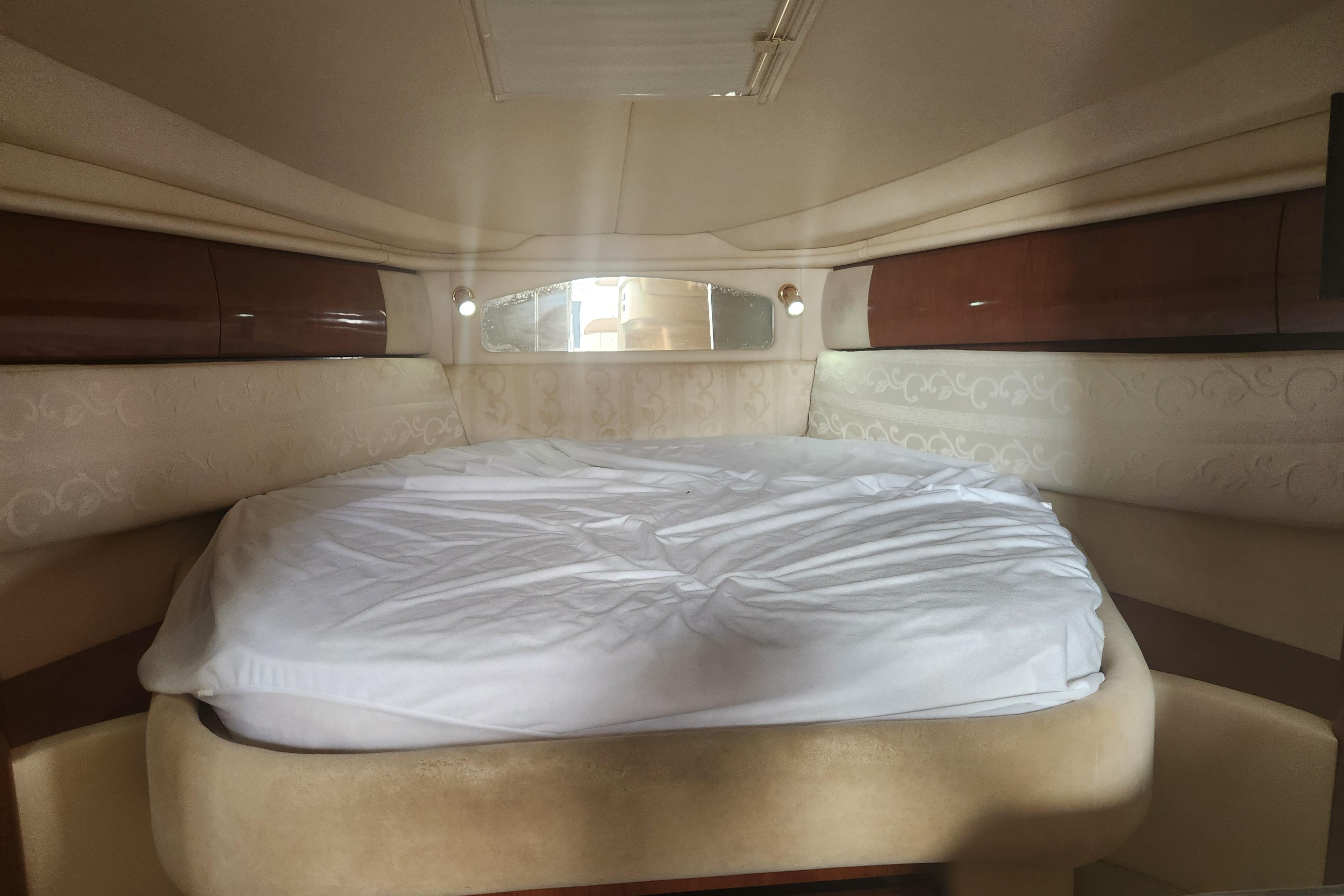 Interior cabin of 2003 Sea Ray 360 Sundancer with a neatly made bed.