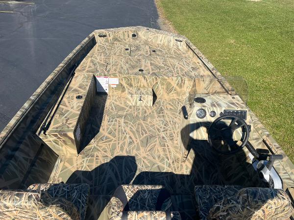 2025 Lowe Roughneck 2070 SC boat with camouflage design, steering console, and seating.