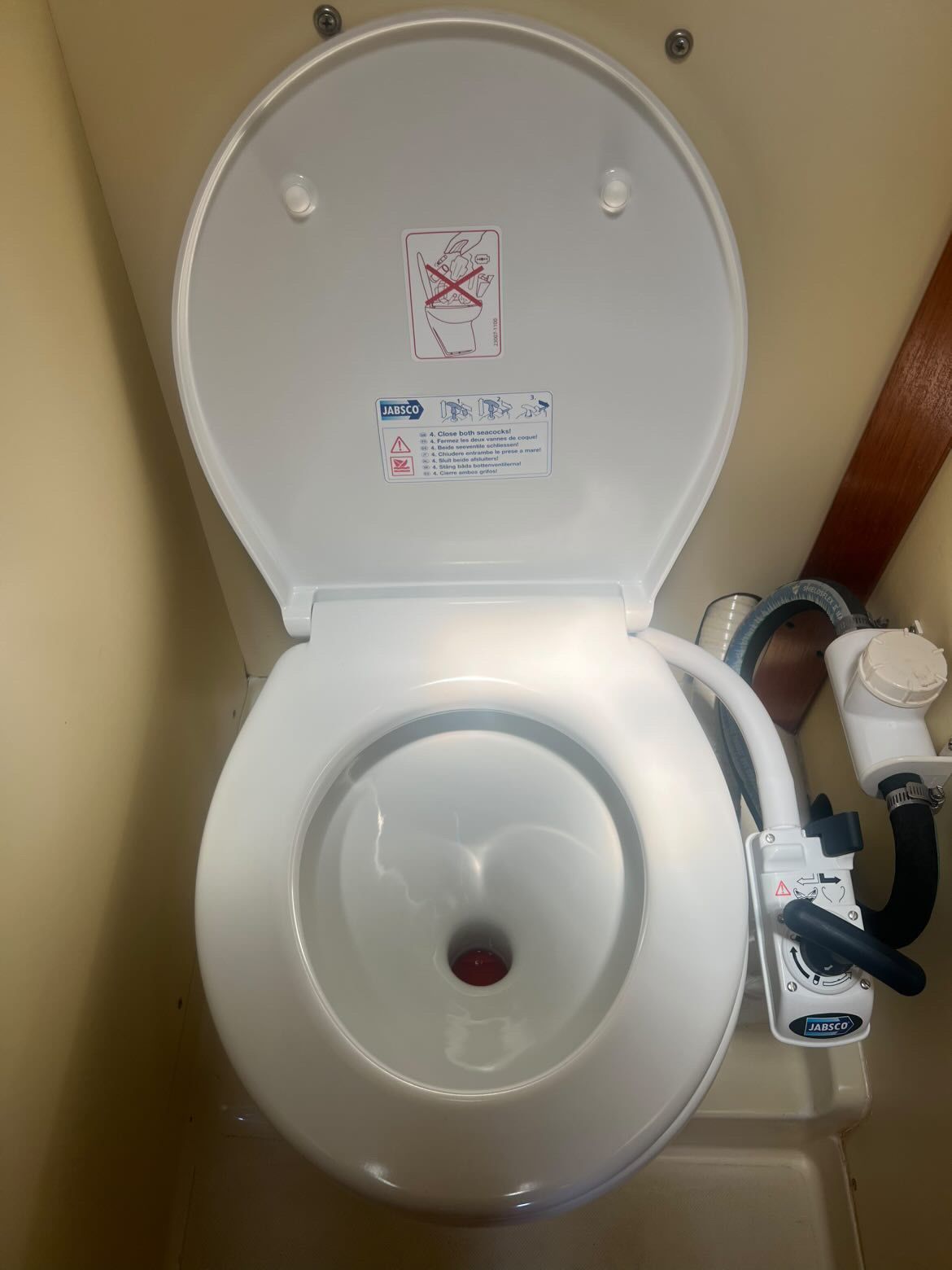 A white boat toilet with an open lid and instructions on the inside.