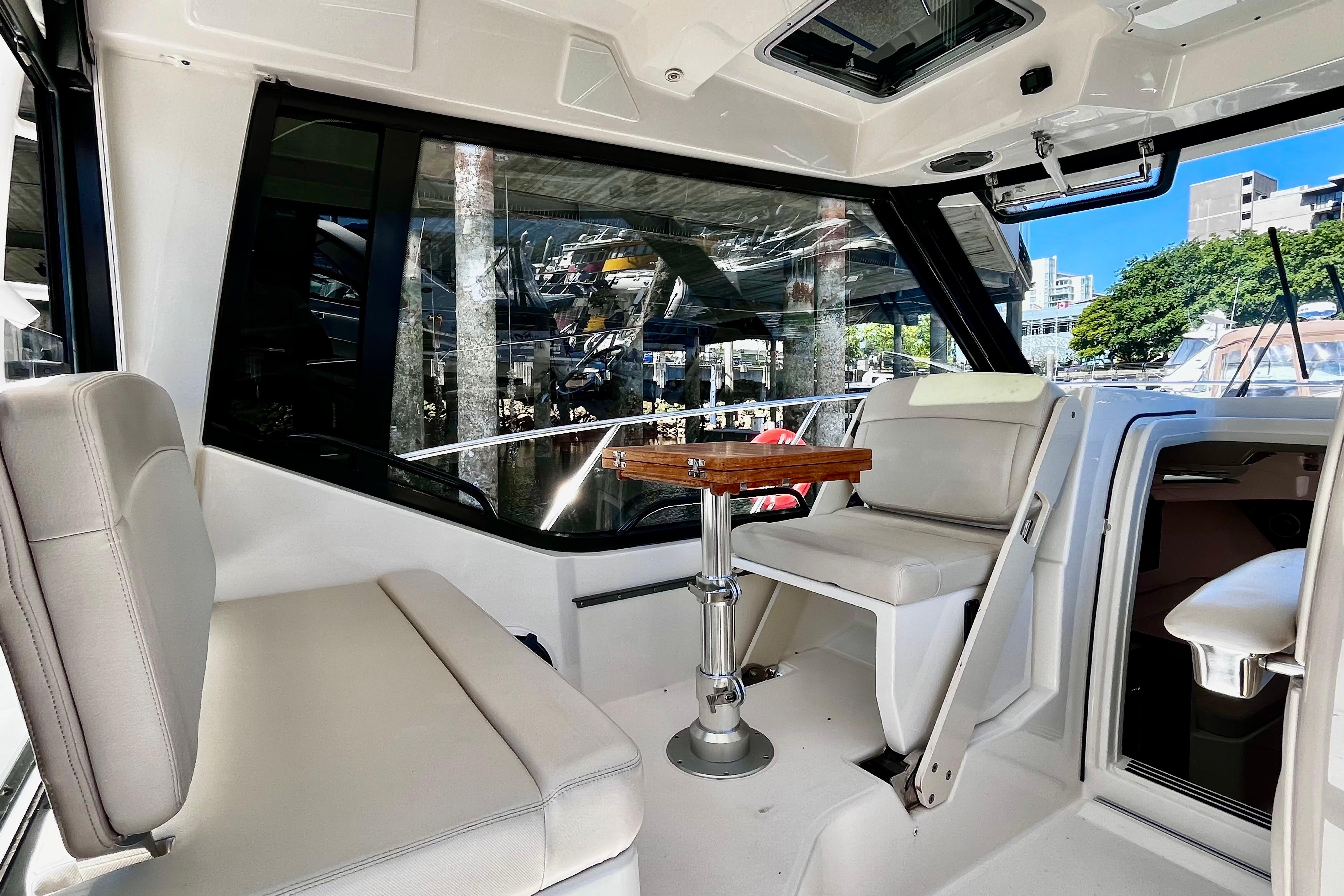 Interior of 2026 Boston Whaler 325 Conquest Pilothouse with seating and table.