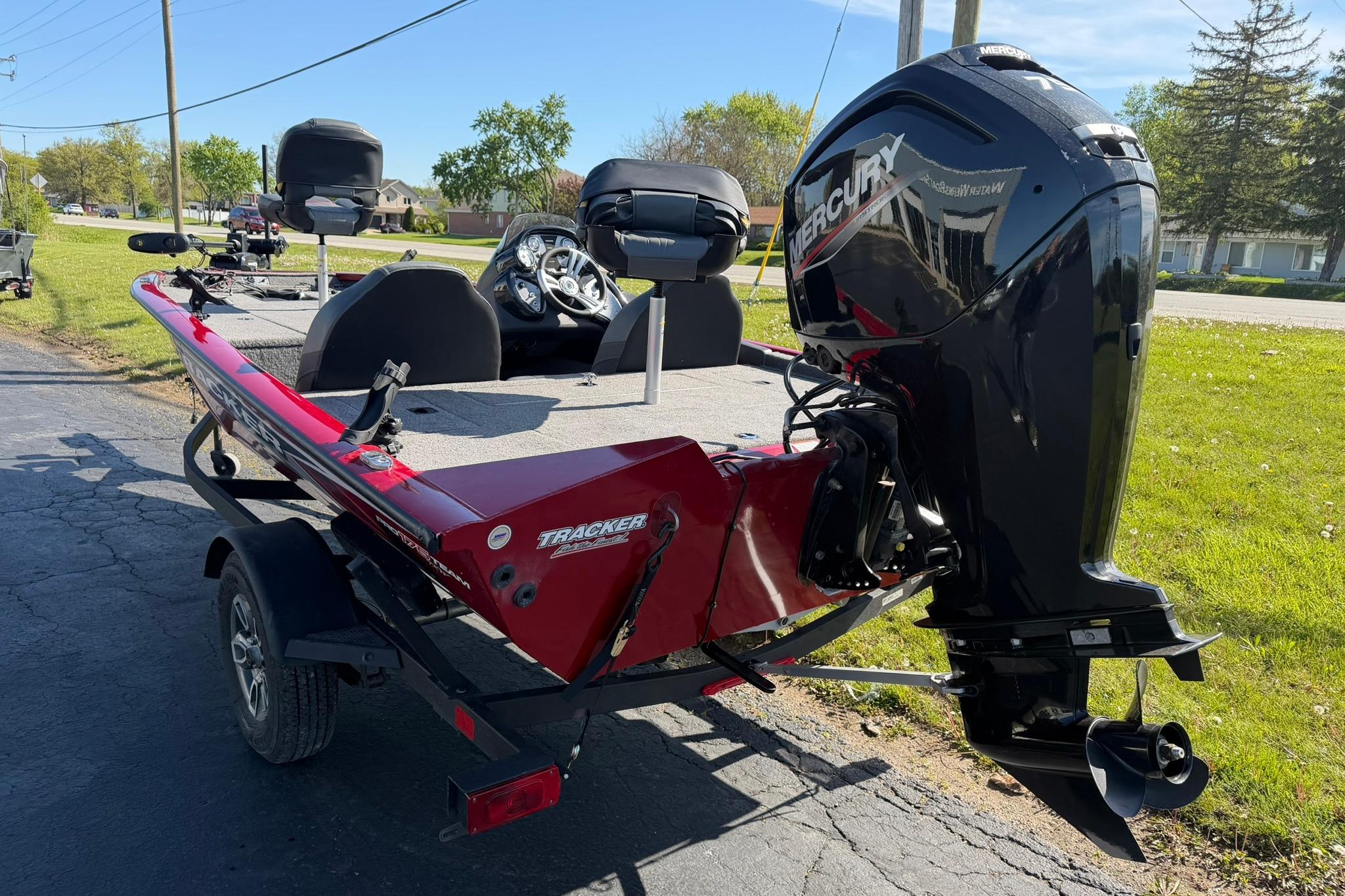 2024 Tracker Pro Team 175 TXW boat with Mercury engine, parked on a sunny day.