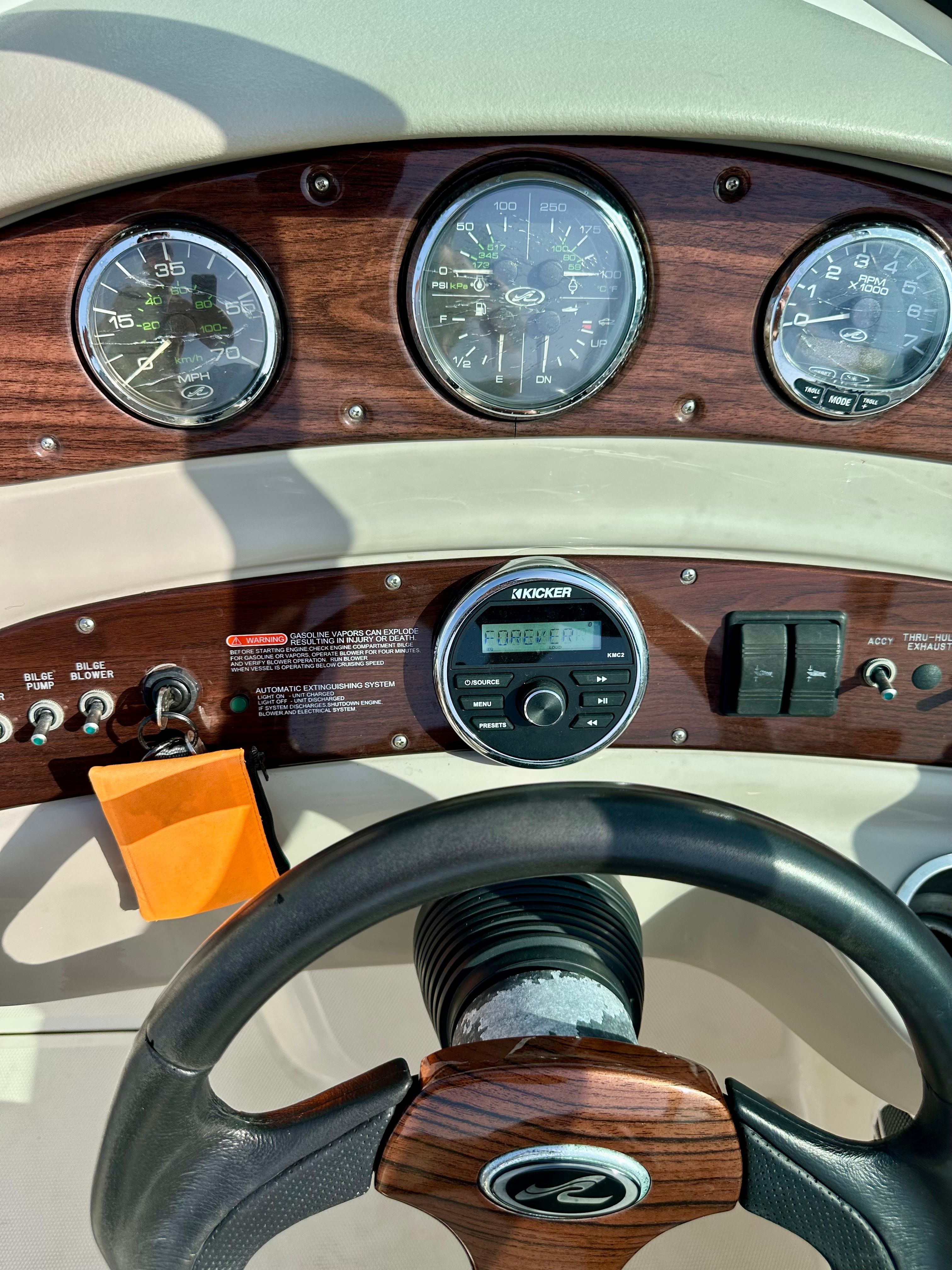 Dashboard of a 2006 Sea Ray 240 Sundeck boat with wood accents.