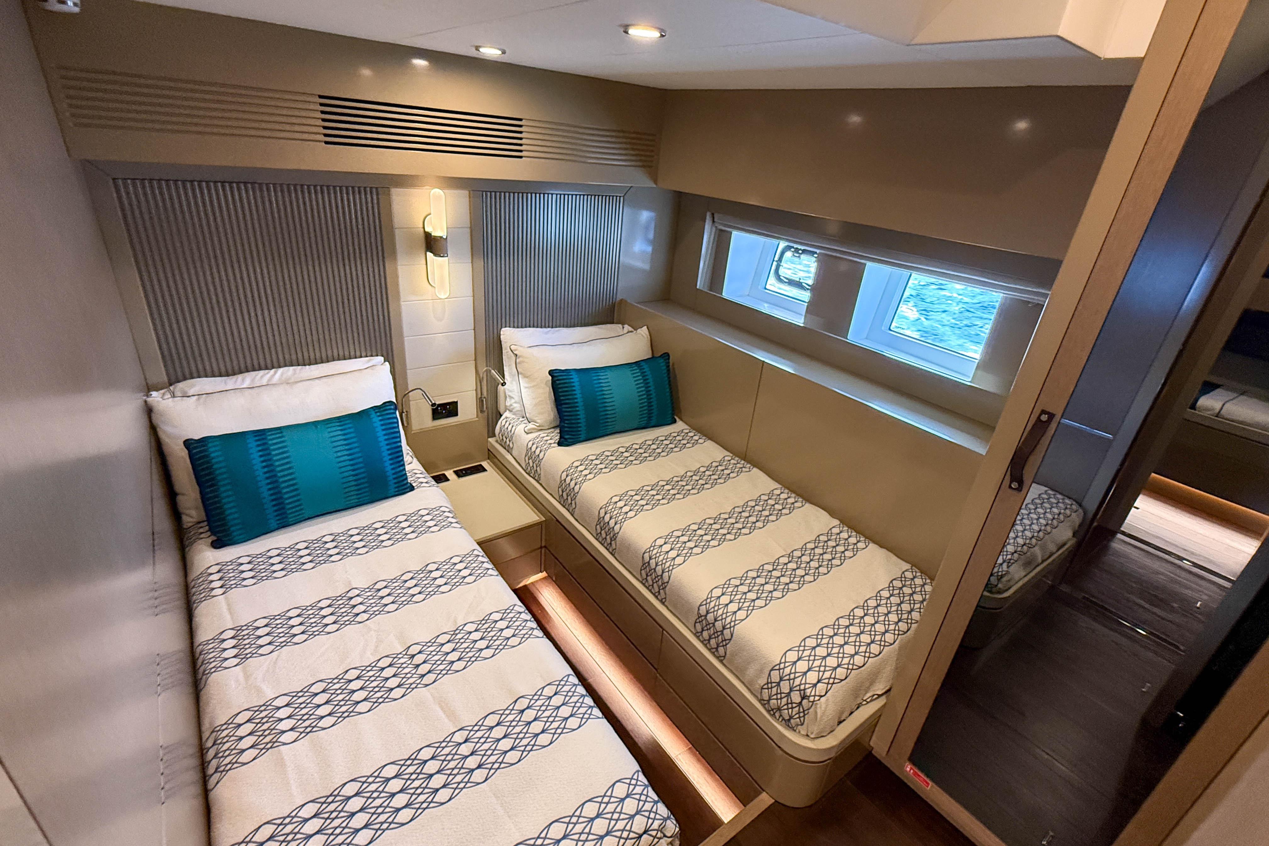 Luxurious 2023 Sirena 68 yacht cabin with twin beds and modern decor.