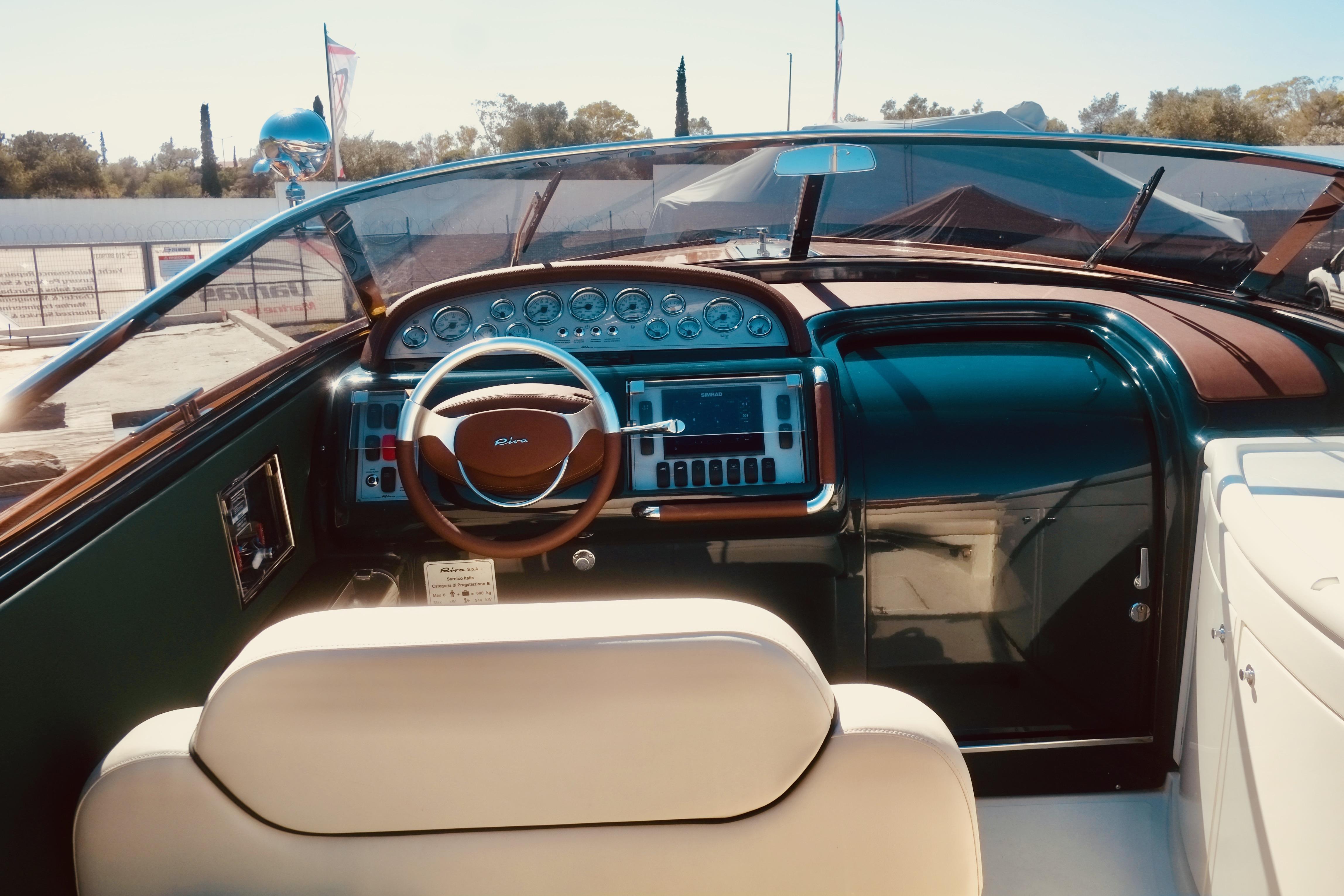 Interior view of a 2003 Riva Aquariva 33 boat, featuring a classic wooden dashboard and steering wheel.