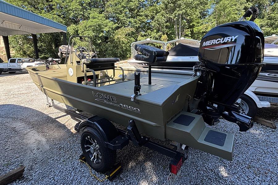 2022 Lowe Roughneck 1660 boat with Mercury engine, parked on gravel lot.