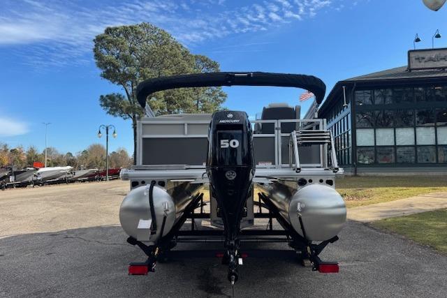 2026 Sun Tracker Bass Buggy 16 XL Select pontoon boat with Mercury 50 engine, parked outdoors.