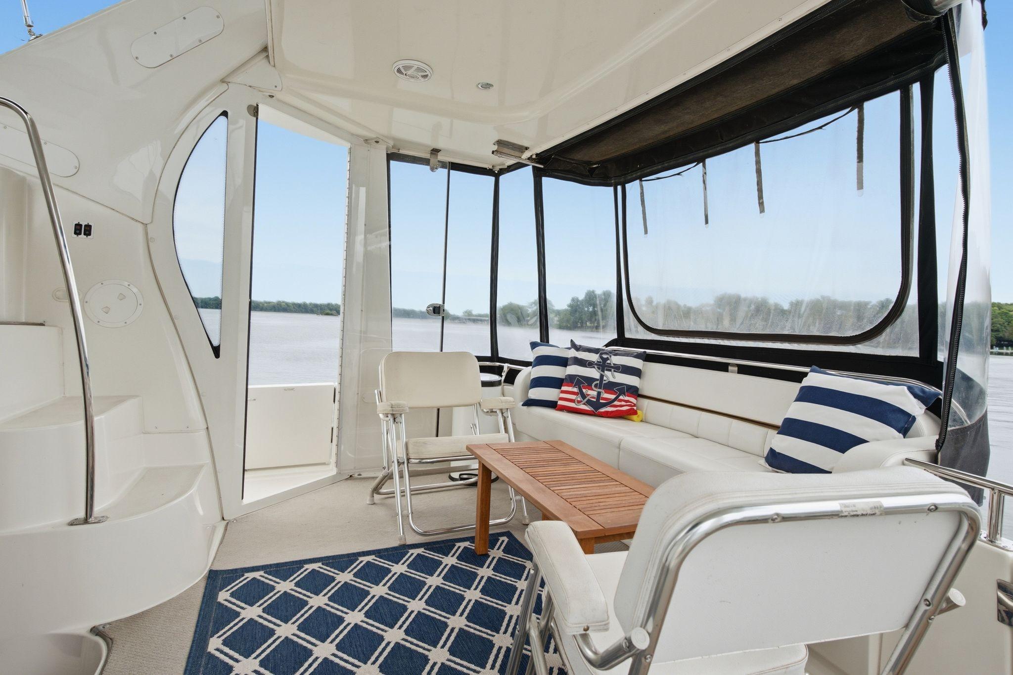 2005 Carver 39 Motor Yacht interior with seating, nautical decor, and river view.