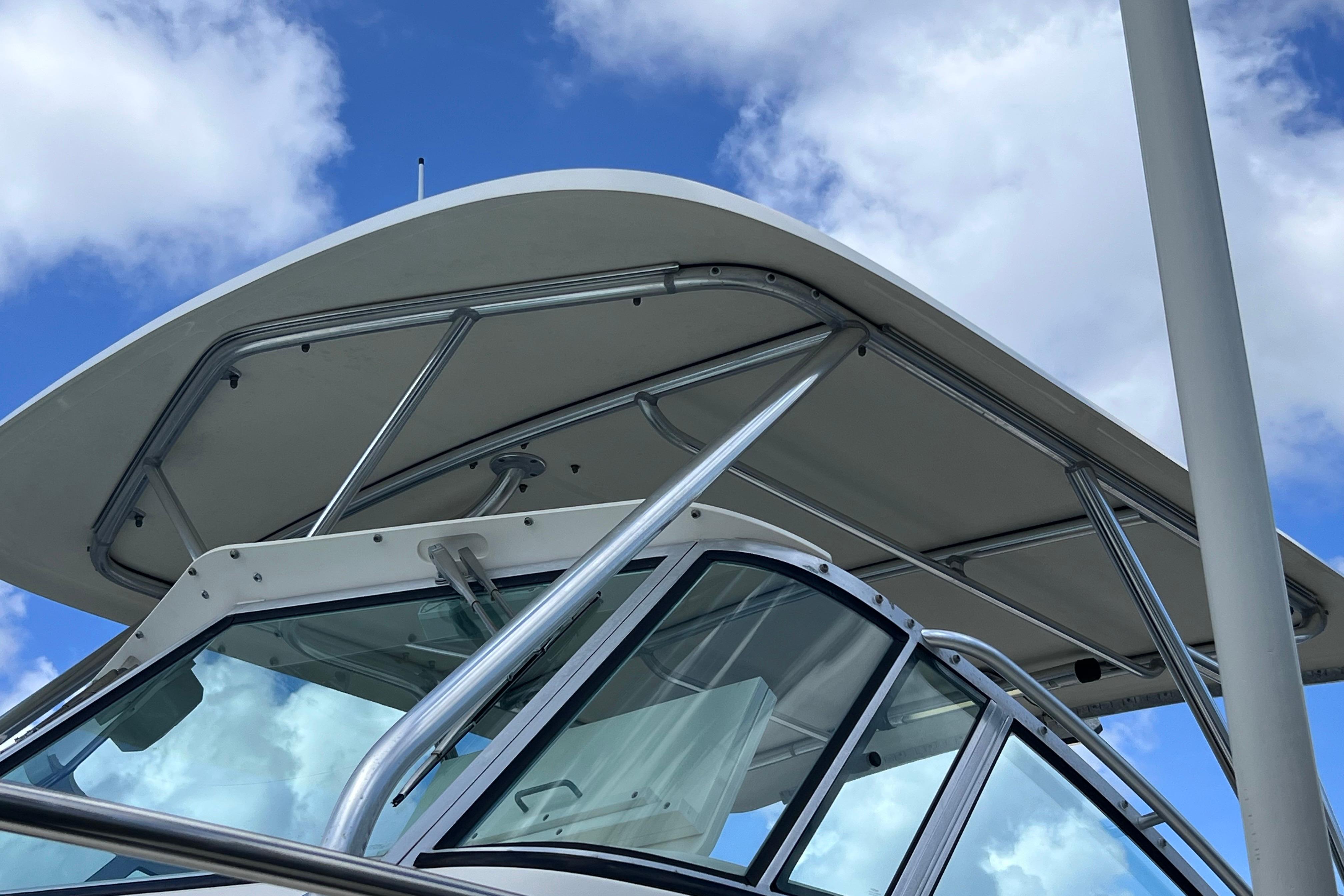2004 Pursuit 2870 Walkaround boat with sleek design against a blue sky.