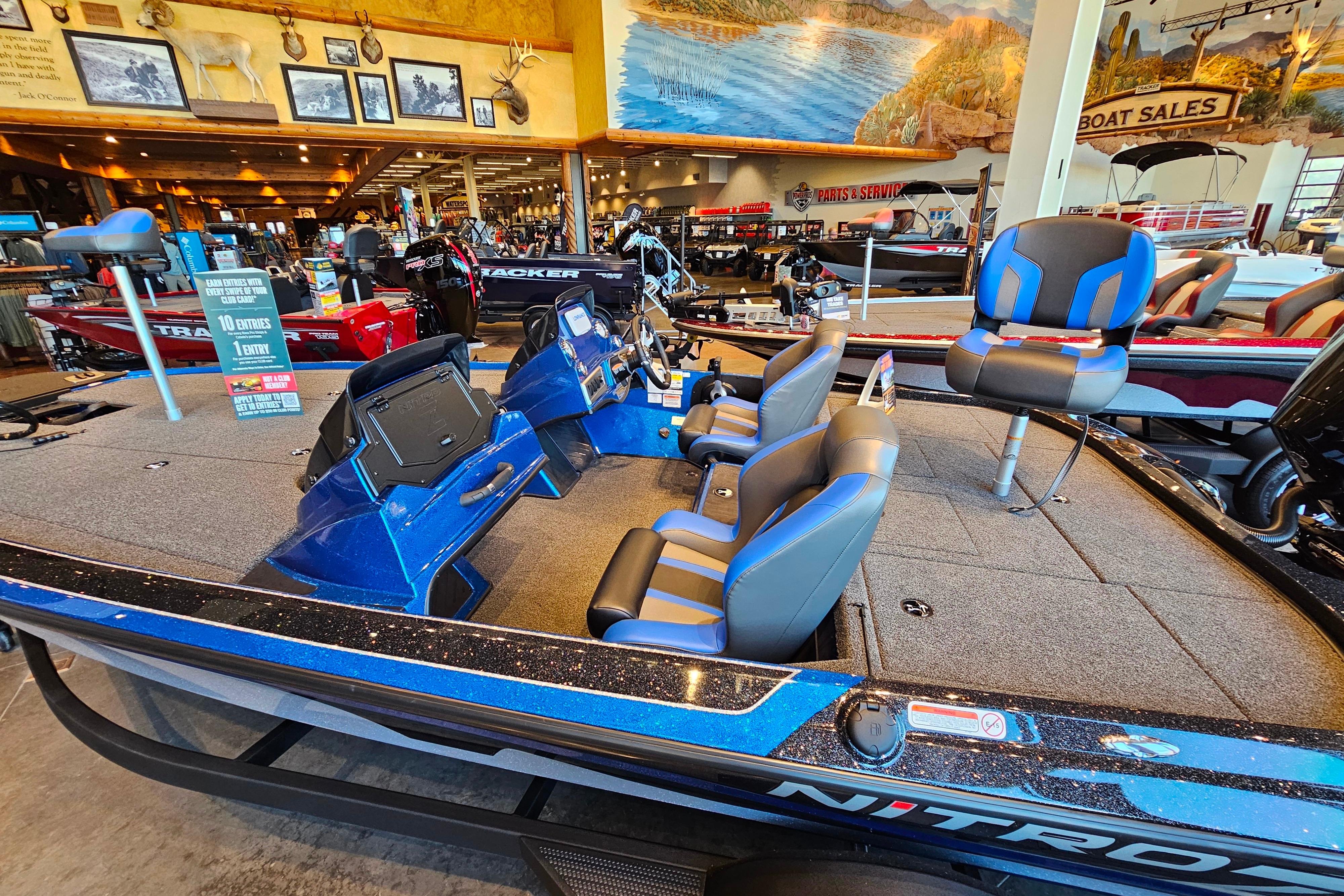 2025 Nitro Z19 boat in showroom, featuring blue and gray seating, and modern dashboard.