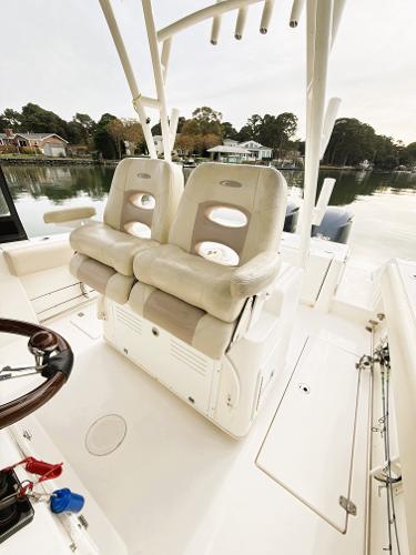 2016 Cobia 296 Center Console boat with dual seats and scenic waterfront view.