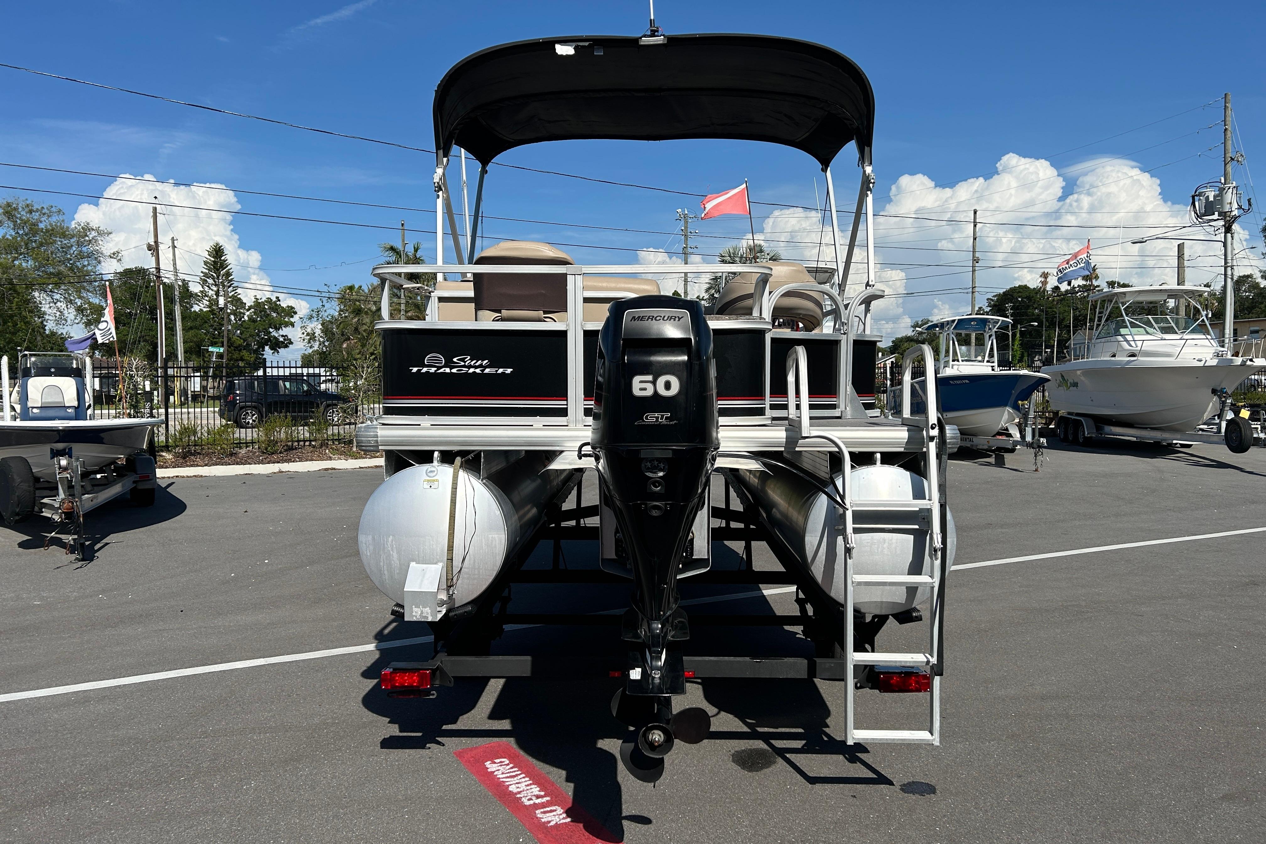 2017 Sun Tracker Bass Buggy 18 DLX pontoon boat with Mercury 60 HP engine, parked outdoors.