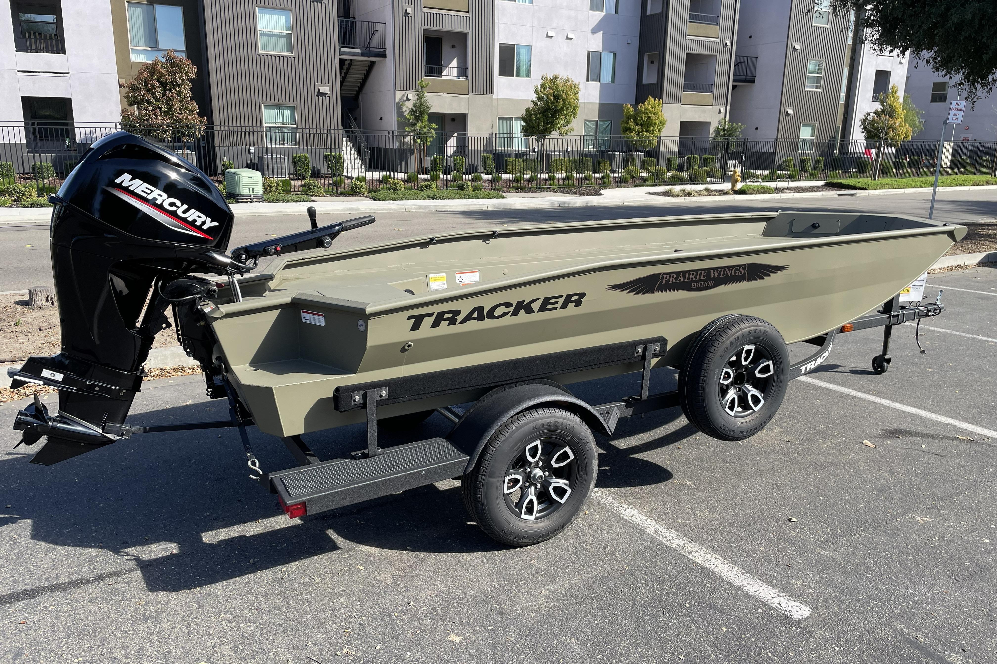 2026 Tracker Grizzly 1650 T Prairie Wings Edition boat with Mercury engine in urban setting.