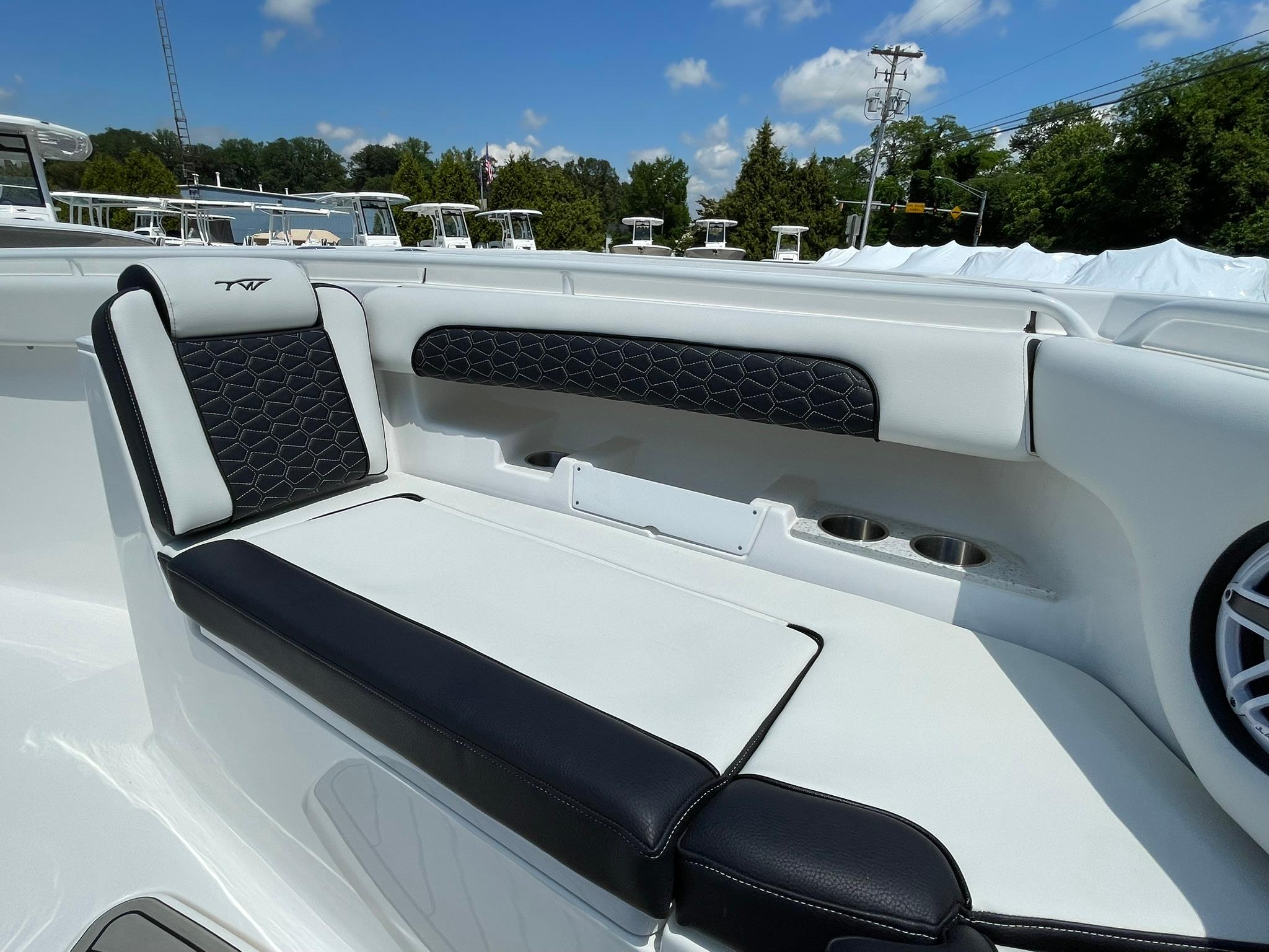 2026 Tidewater 302 CC Adventure boat seating with black and white upholstery, cup holders, and speaker.
