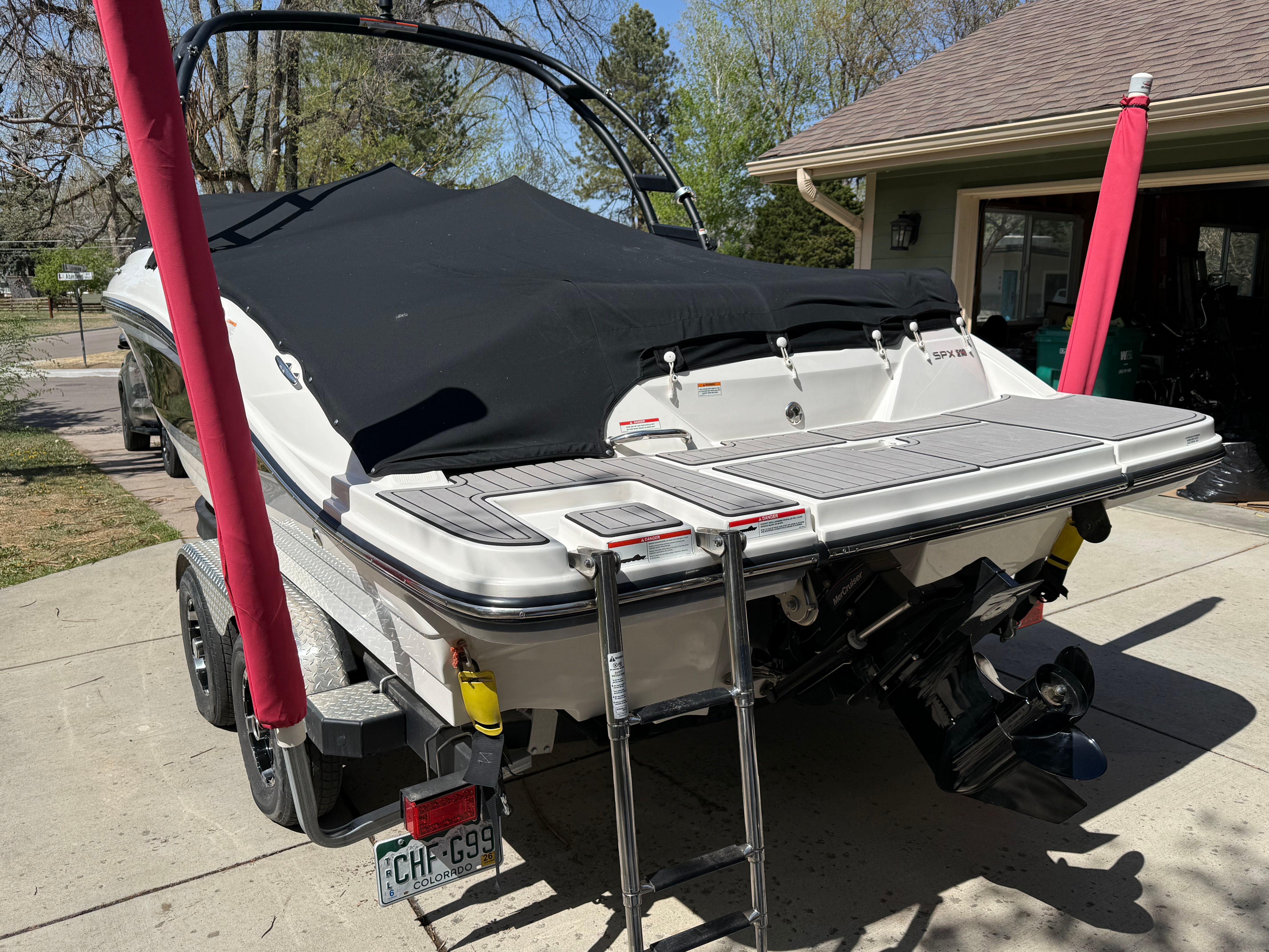 2022 Sea Ray SPX 210 boat on trailer, covered, parked in driveway.