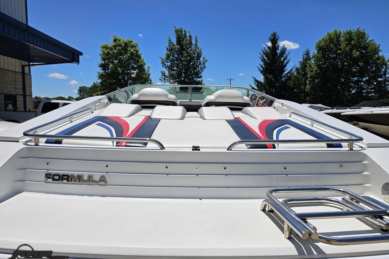 2005 Formula 271 FASTech boat with sleek design and vibrant upholstery under clear blue sky.