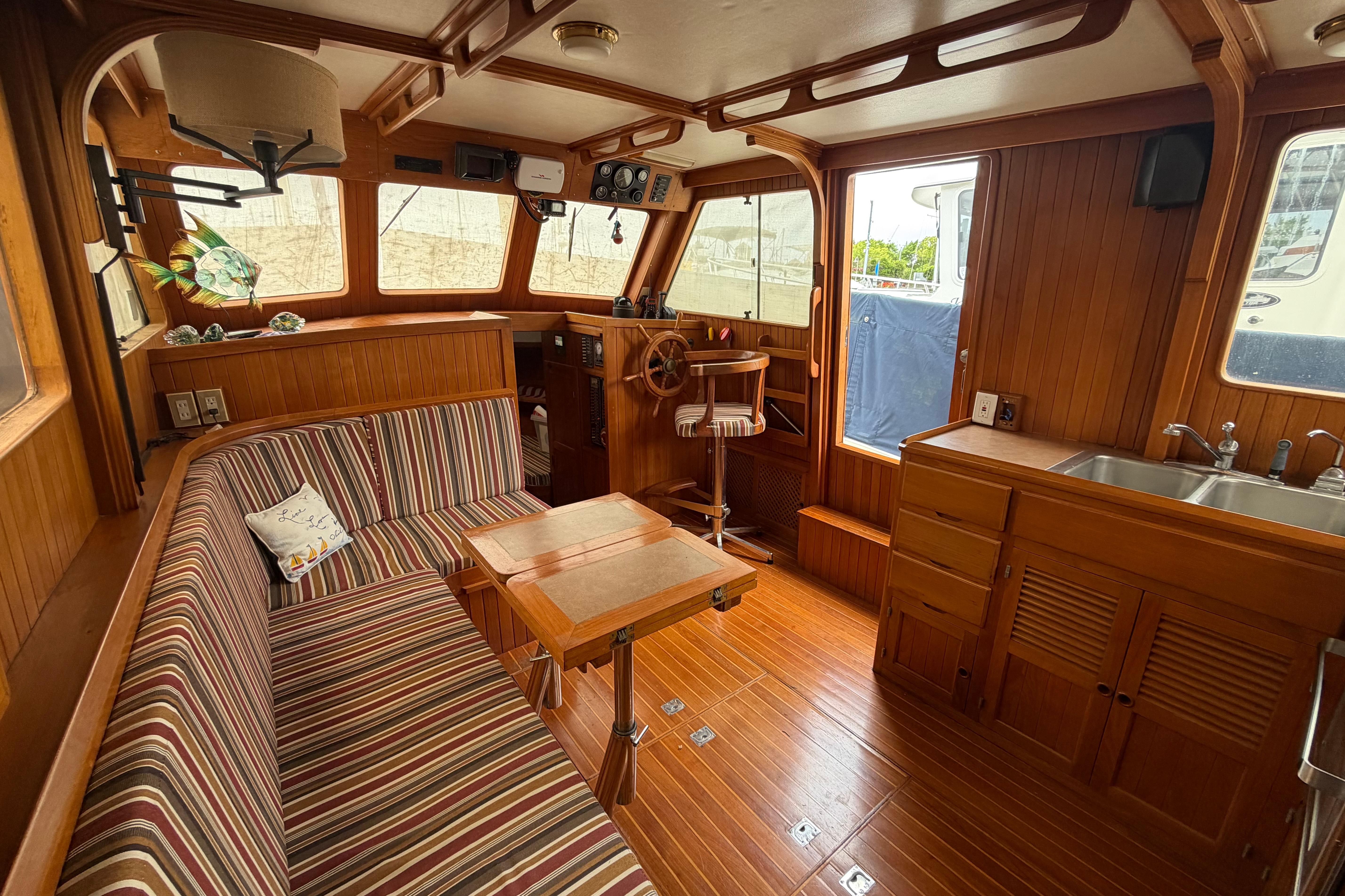 Interior of a 1988 Monk 36 boat with wood paneling and striped seating.