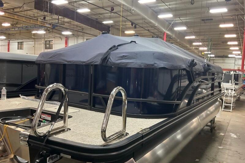 2026 Bennington 22 SSRSE pontoon boat in a warehouse, covered and secured.