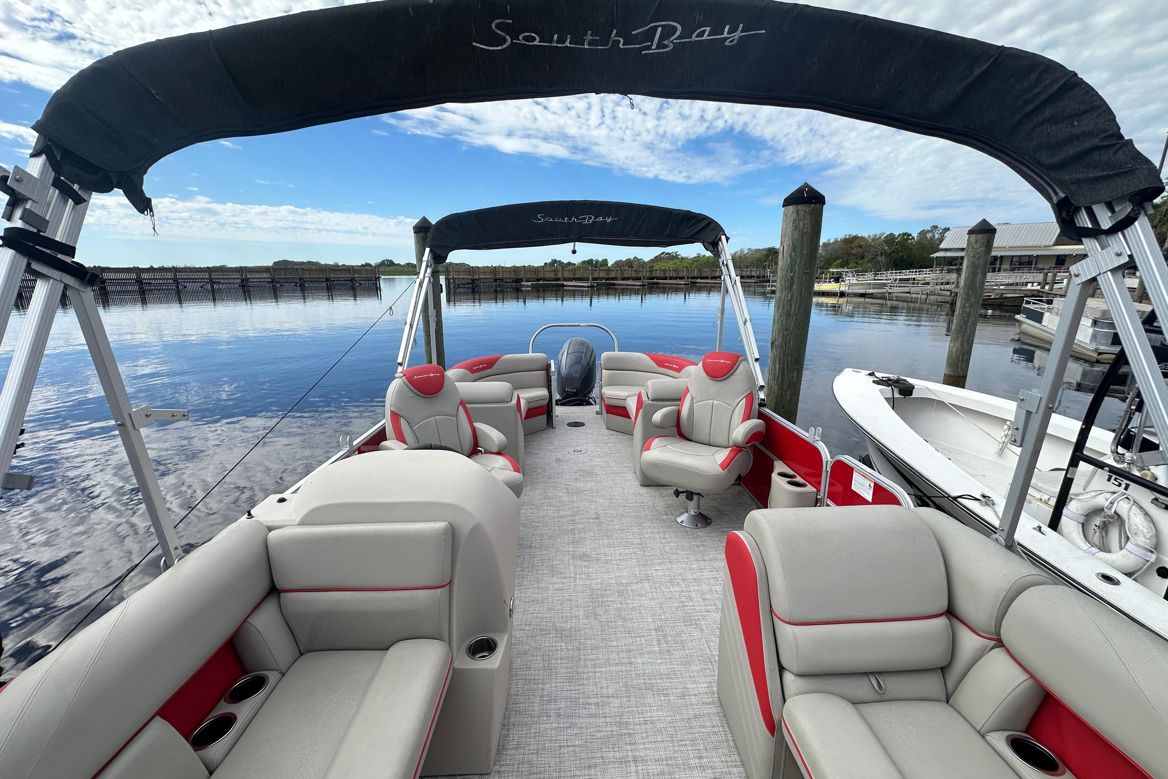 2022 South Bay Pontoons 24 LE Series Tri Hull on calm water, featuring spacious seating.