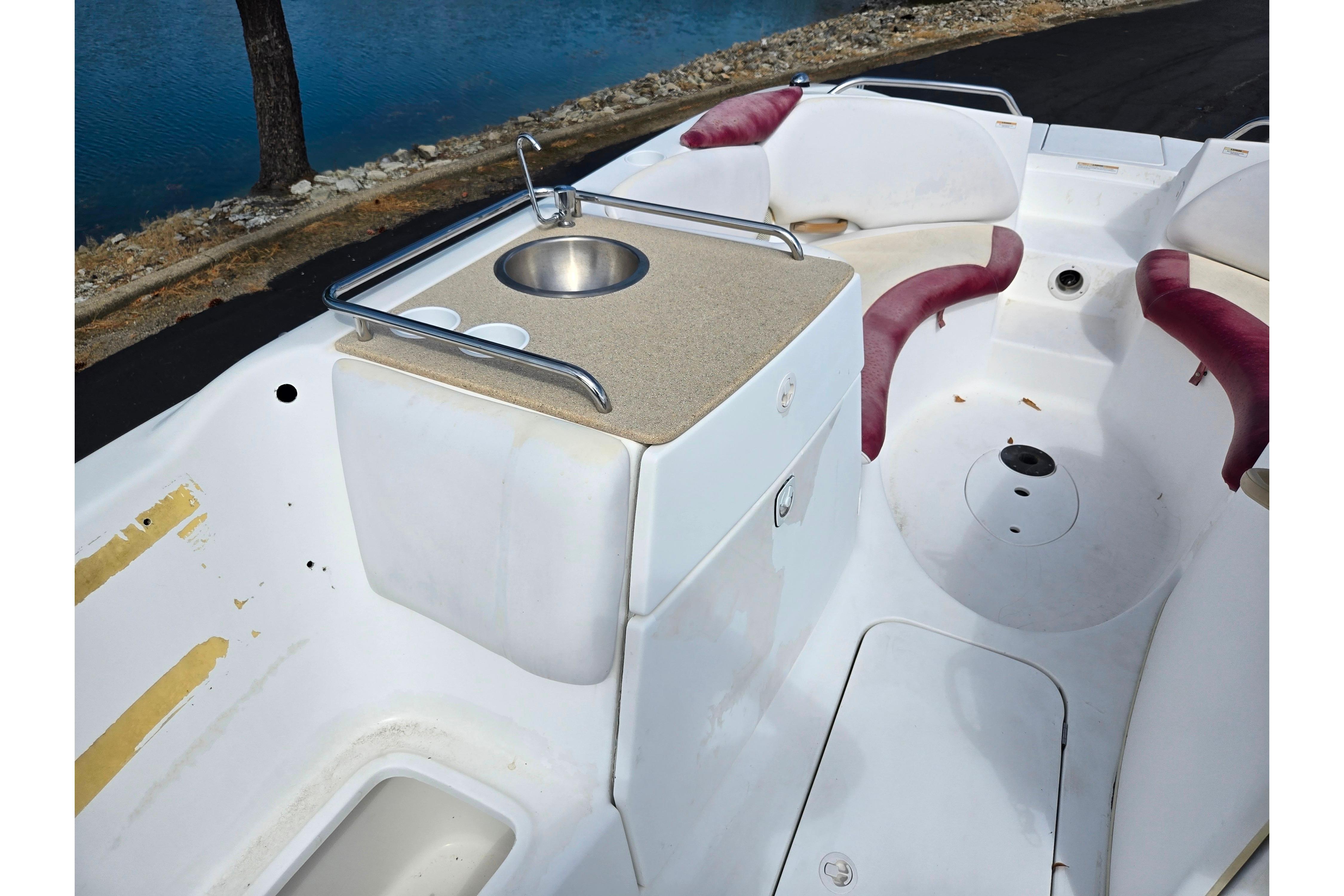 2004 Sea-Doo Islandia boat interior with sink and seating area by the water.