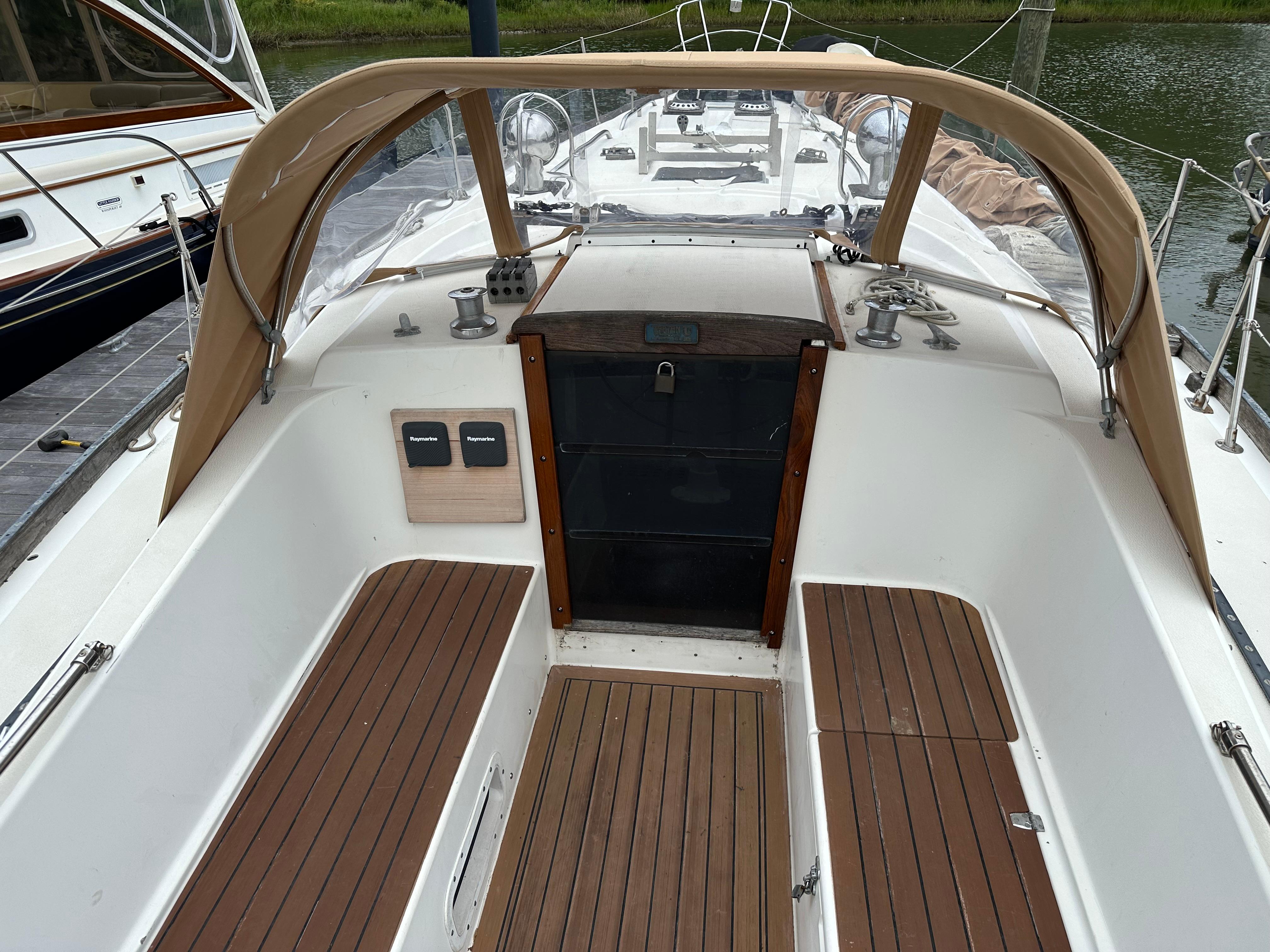 1981 Tartan 37 sloop cockpit with wooden seating and tan canopy.