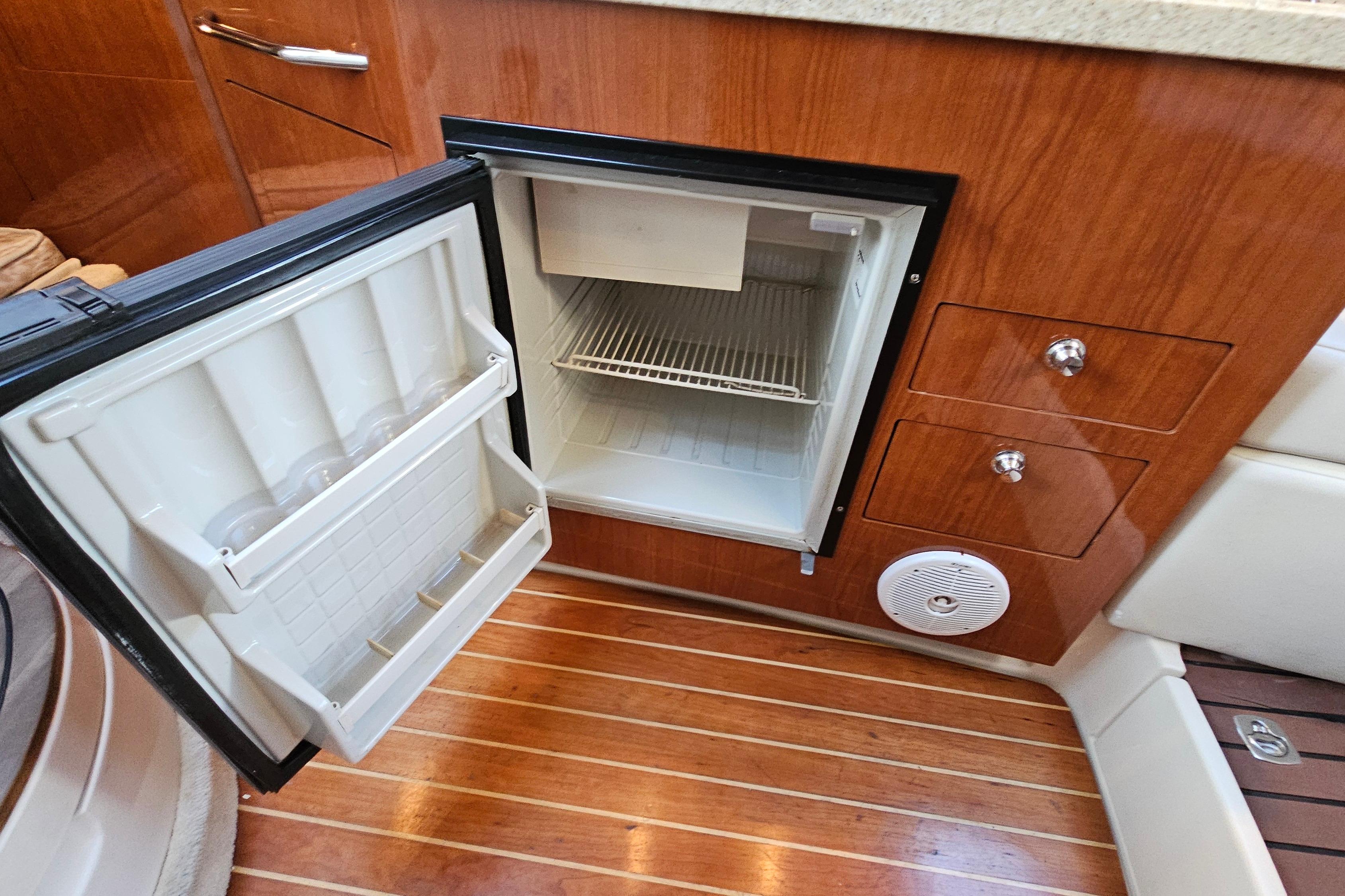 Open mini fridge in 2005 Regal 3060 Window Express boat interior.