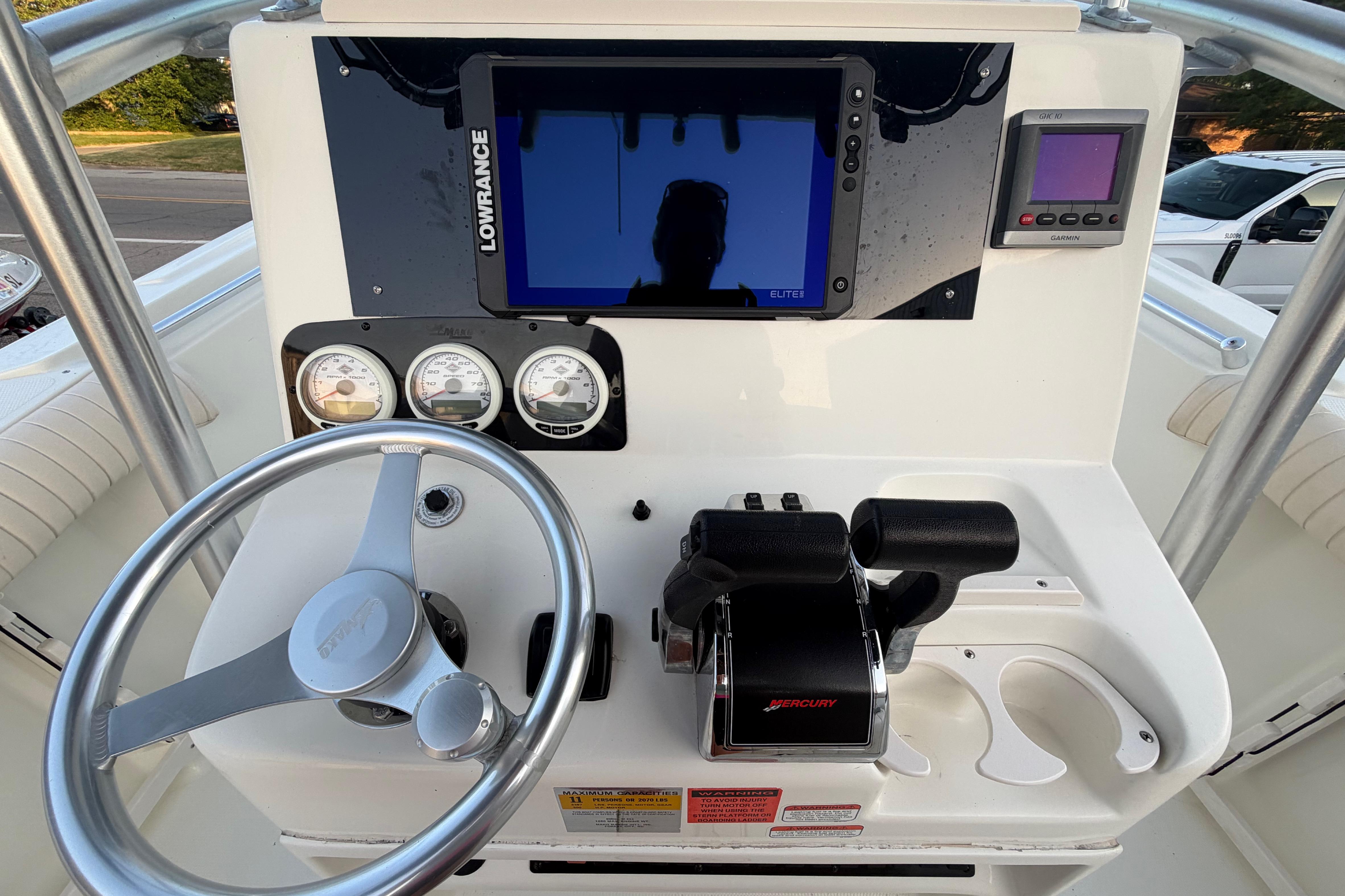 Center console of 2007 Mako 234 boat with steering wheel, gauges, and navigation equipment.