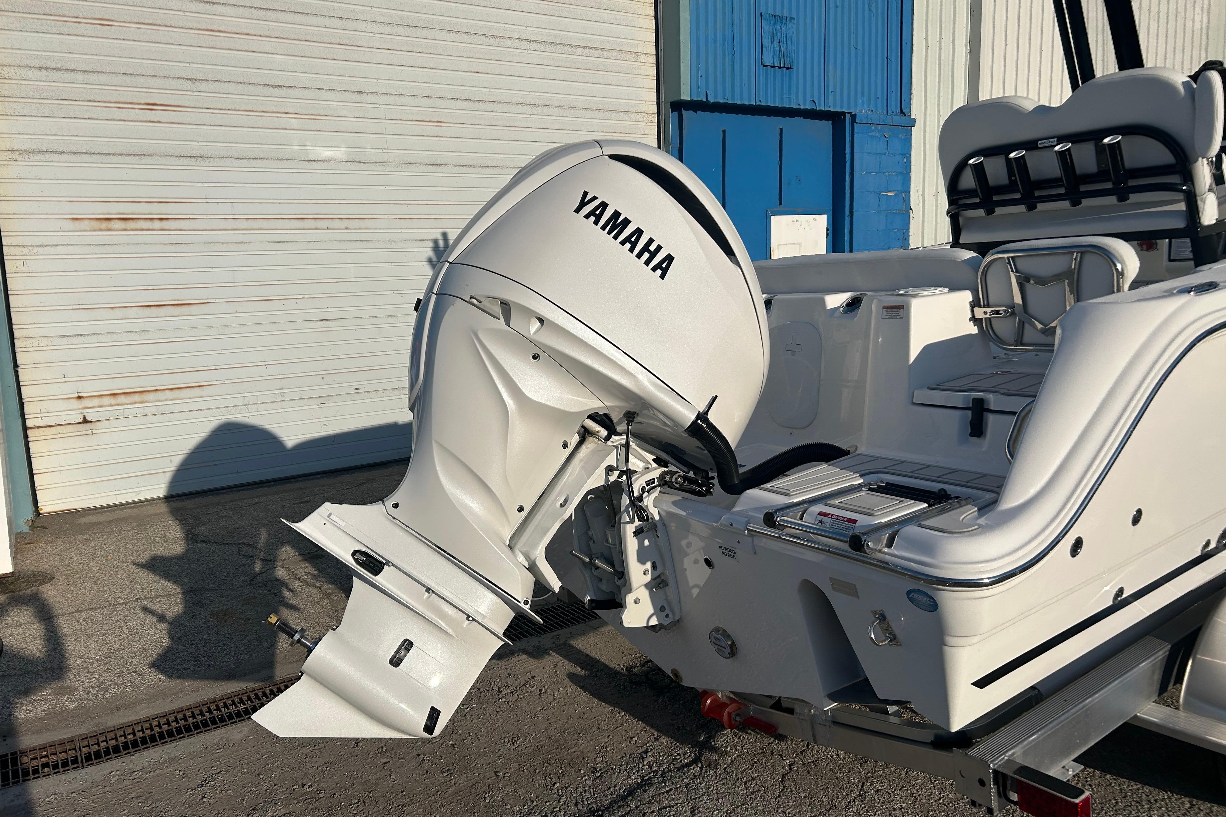 2026 Sea Fox 248 Commander boat with Yamaha outboard motor, parked near a garage.