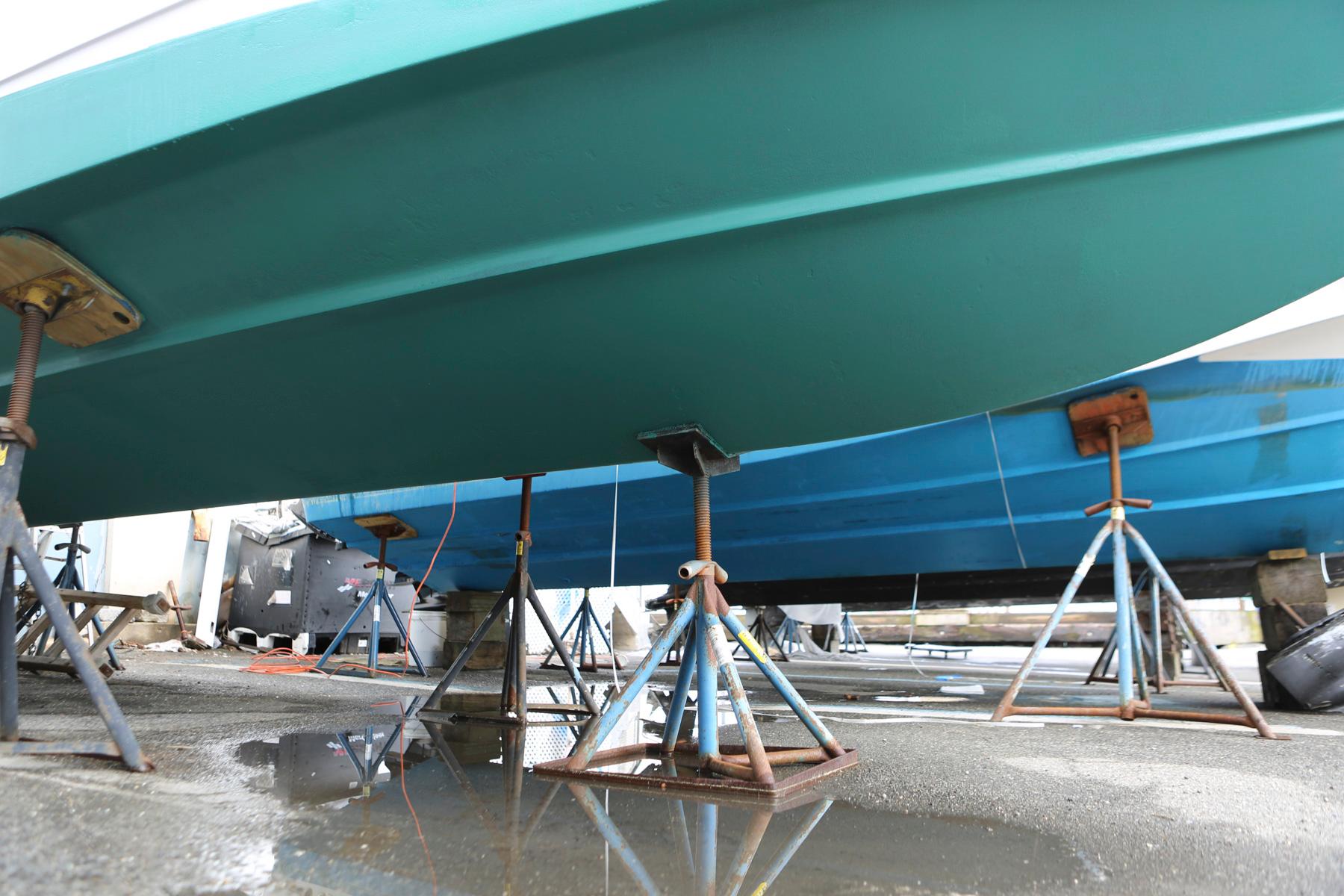 2007 Four Winns 278 Vista boat on stands, underside view, in a maintenance area.