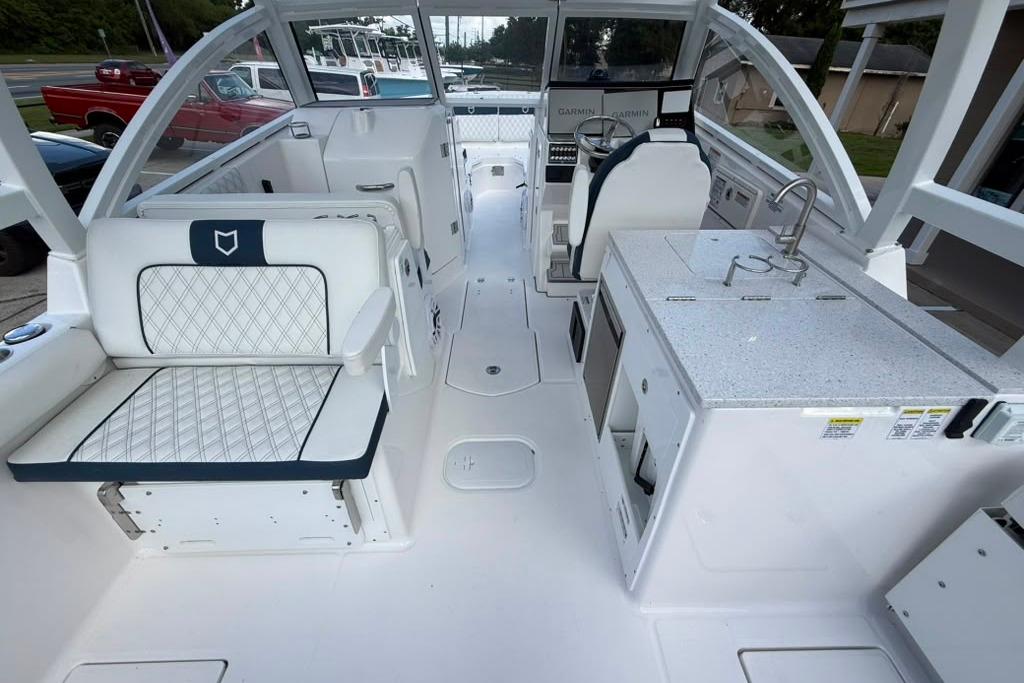 Interior view of 2026 Sea Fox 288 Traveler boat, featuring seating and kitchenette.