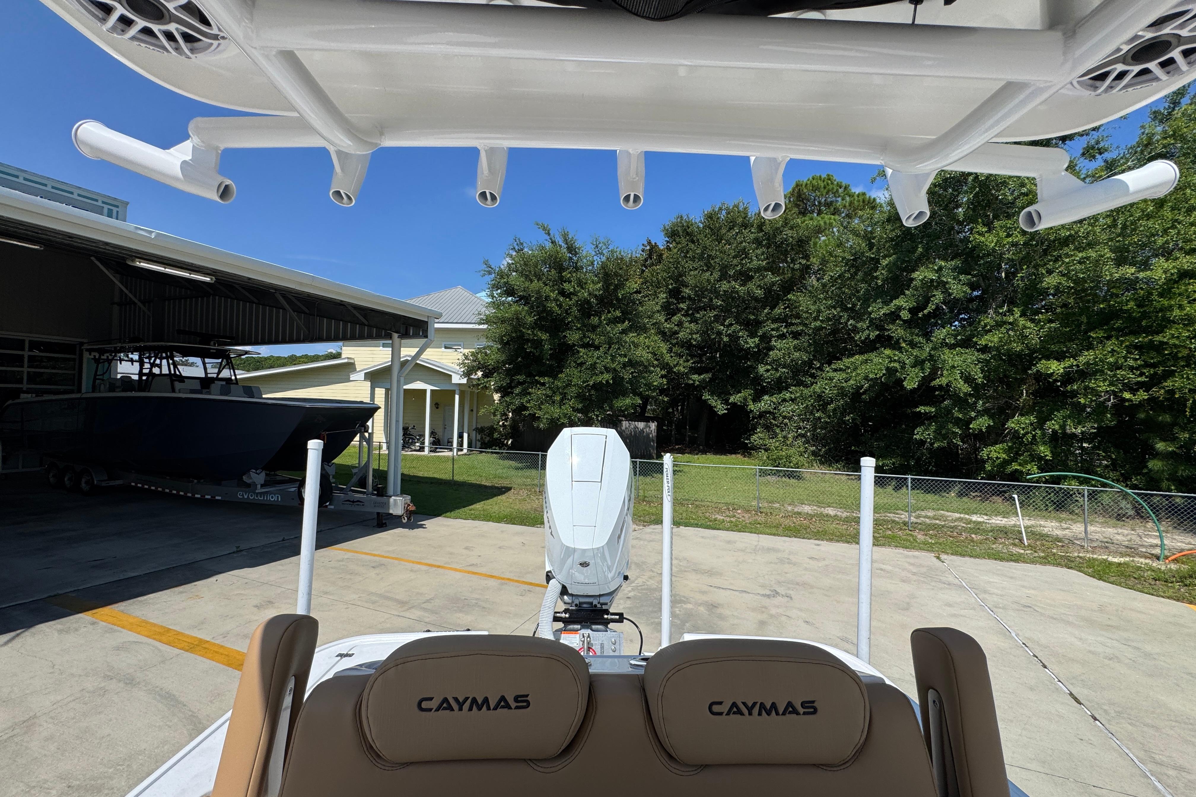 2027 Caymas 26 HB boat parked outdoors, showcasing rod holders and seating.