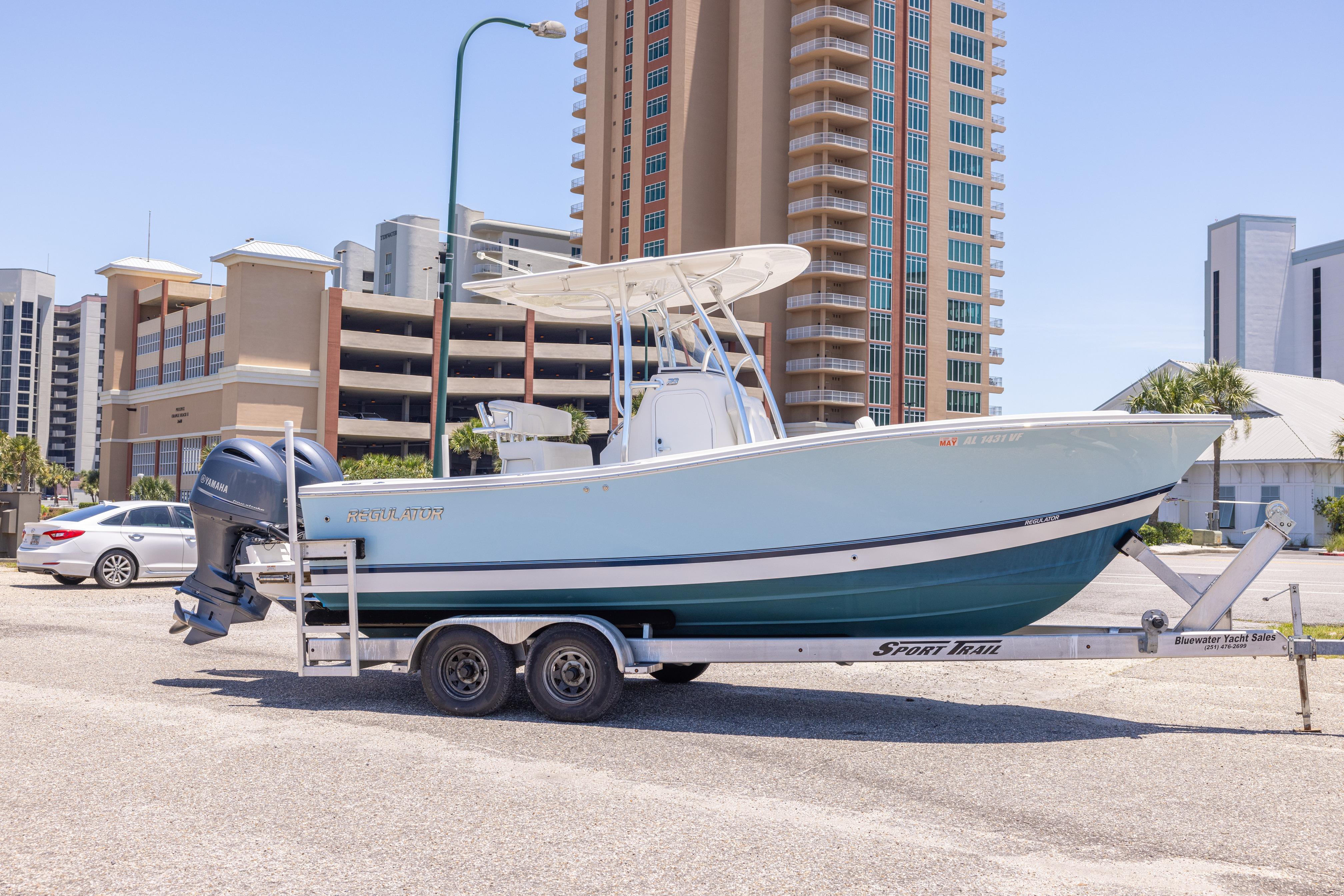2019 Regulator 23 Center Console boat on trailer, urban background, sunny day.
