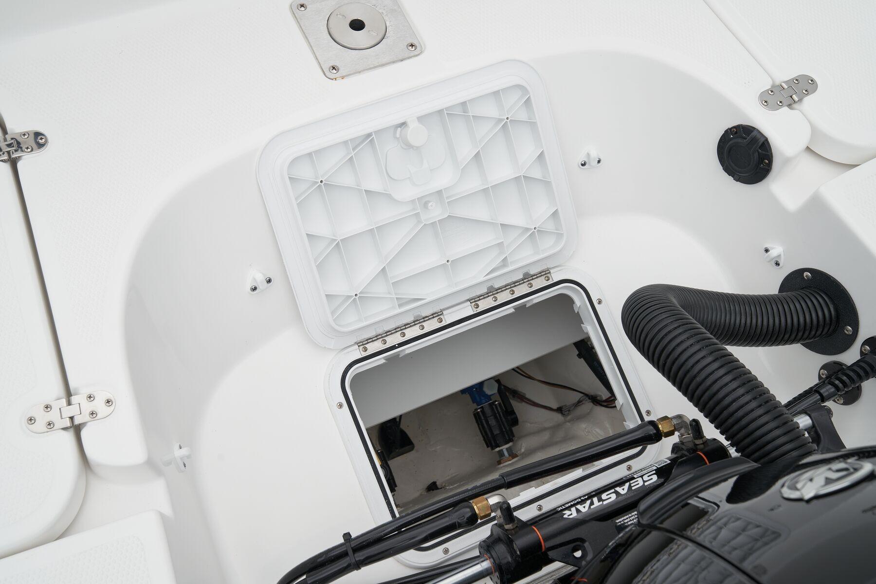 Open storage compartment in 2023 Tahoe 1950 boat, showcasing interior and engine components.