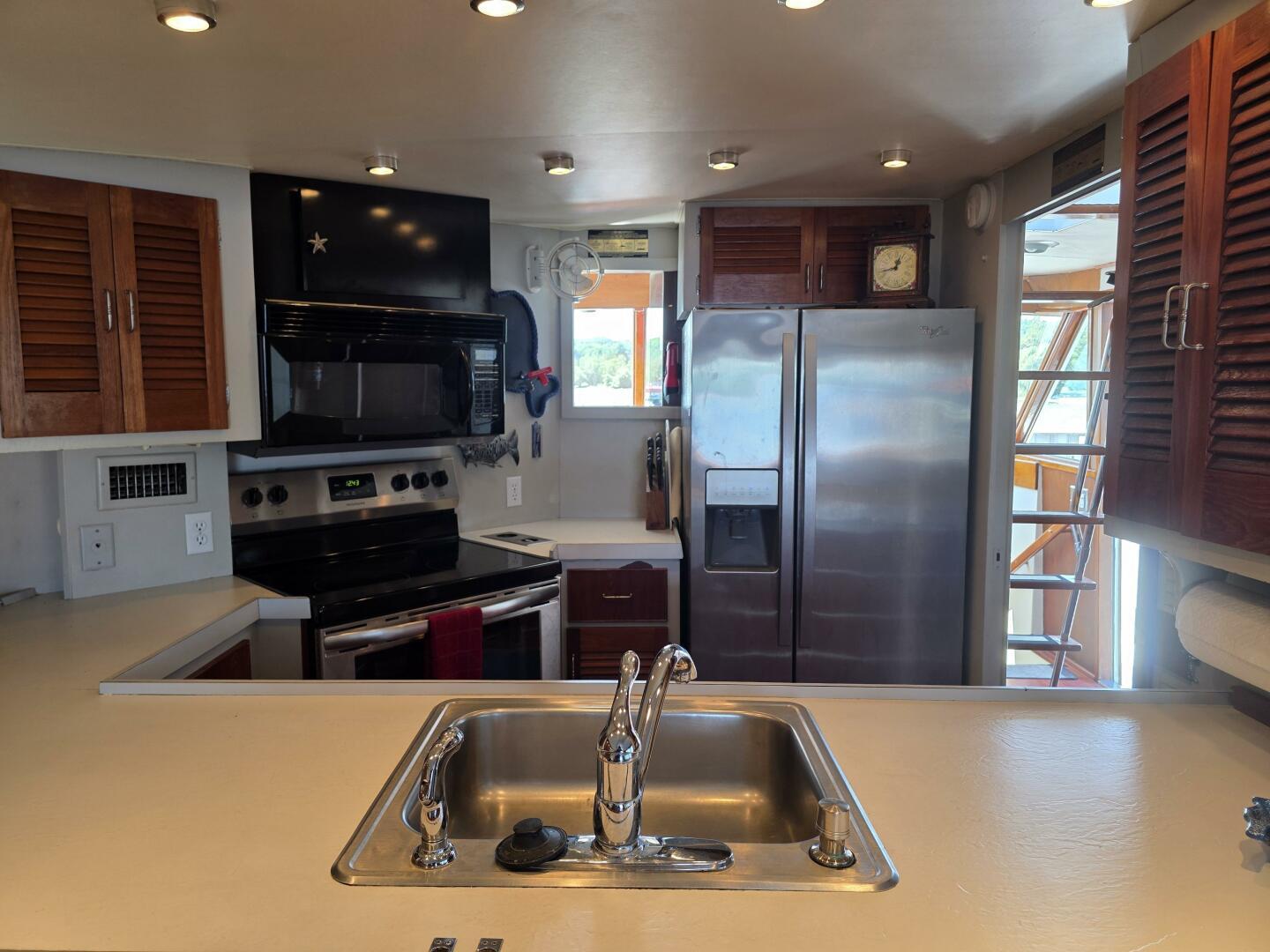 Modern kitchen interior on 1976 Chris-Craft Roamer 60 yacht with stainless steel appliances.
