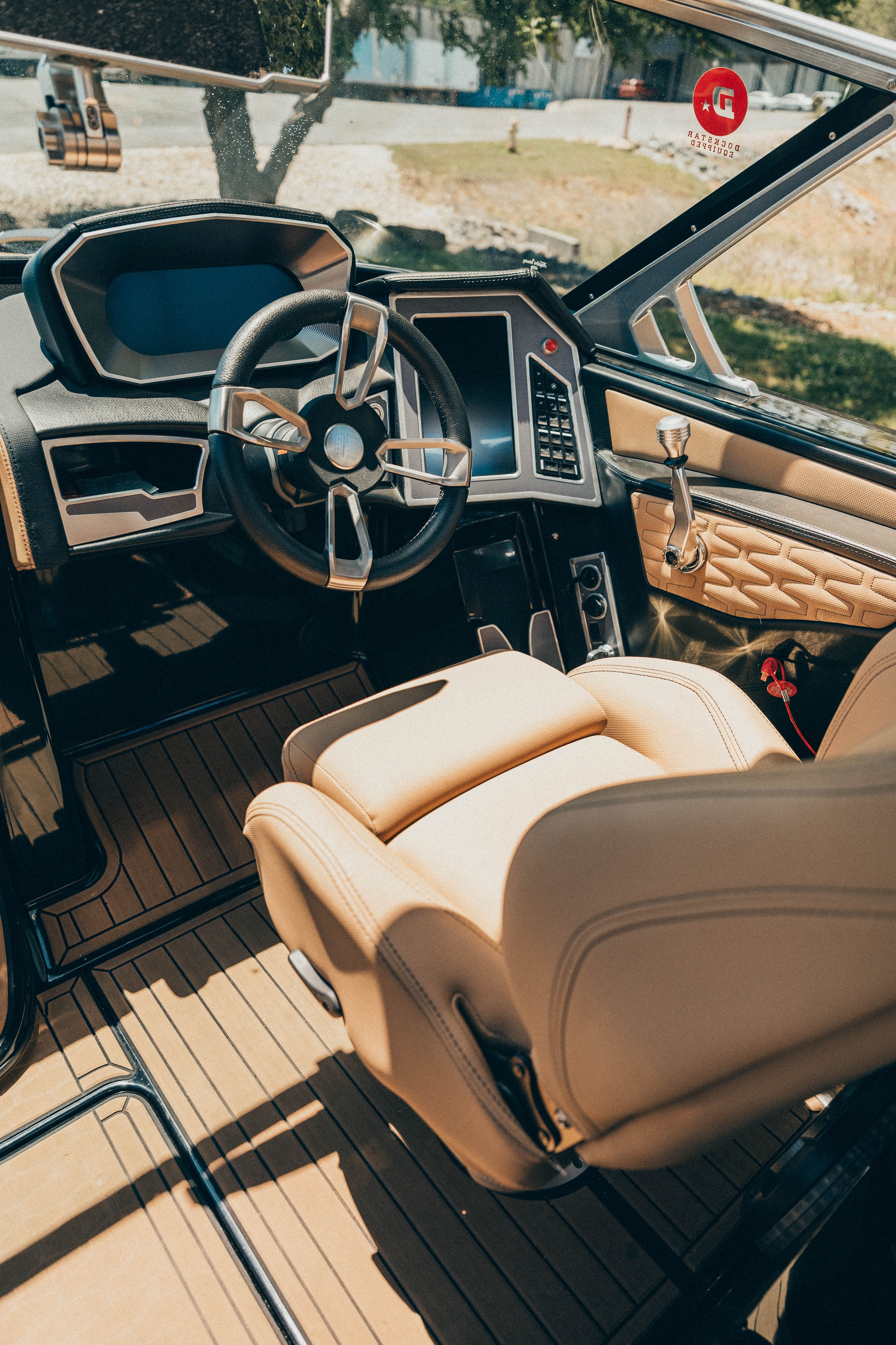 The image shows the cockpit of a 2021 MasterCraft X26 with luxurious seating and a modern dashboard.