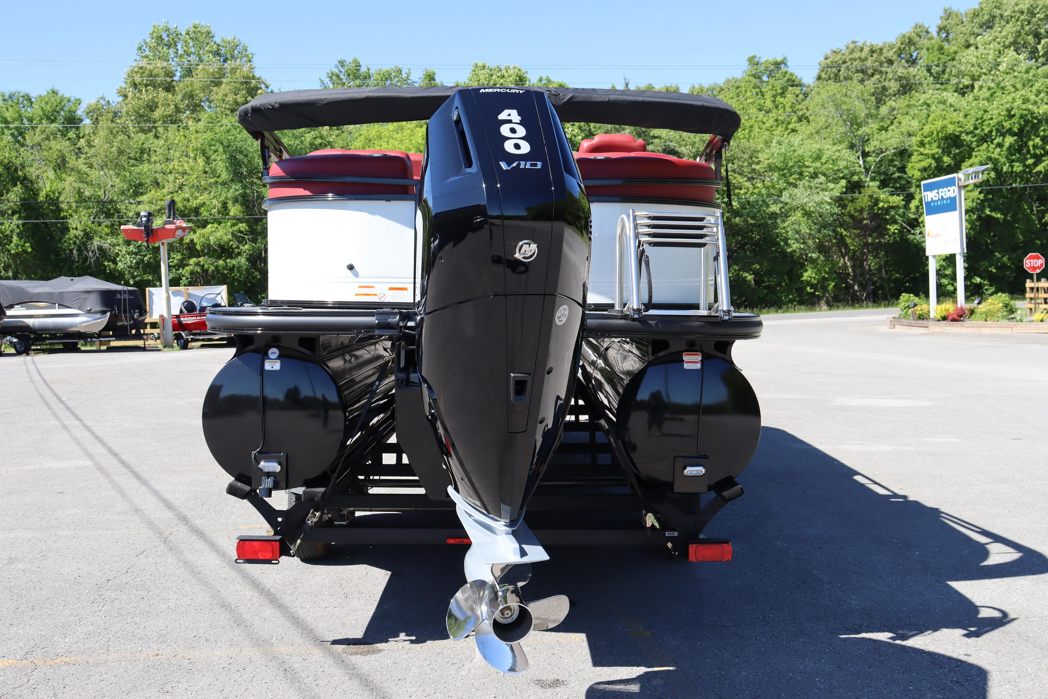 2026 Regency 250 DL pontoon boat with powerful Mercury 400 V10 engine, parked outdoors.