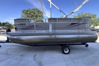 2012 Avalon Tahoe pontoon boat on trailer, parked outdoors under clear blue sky.