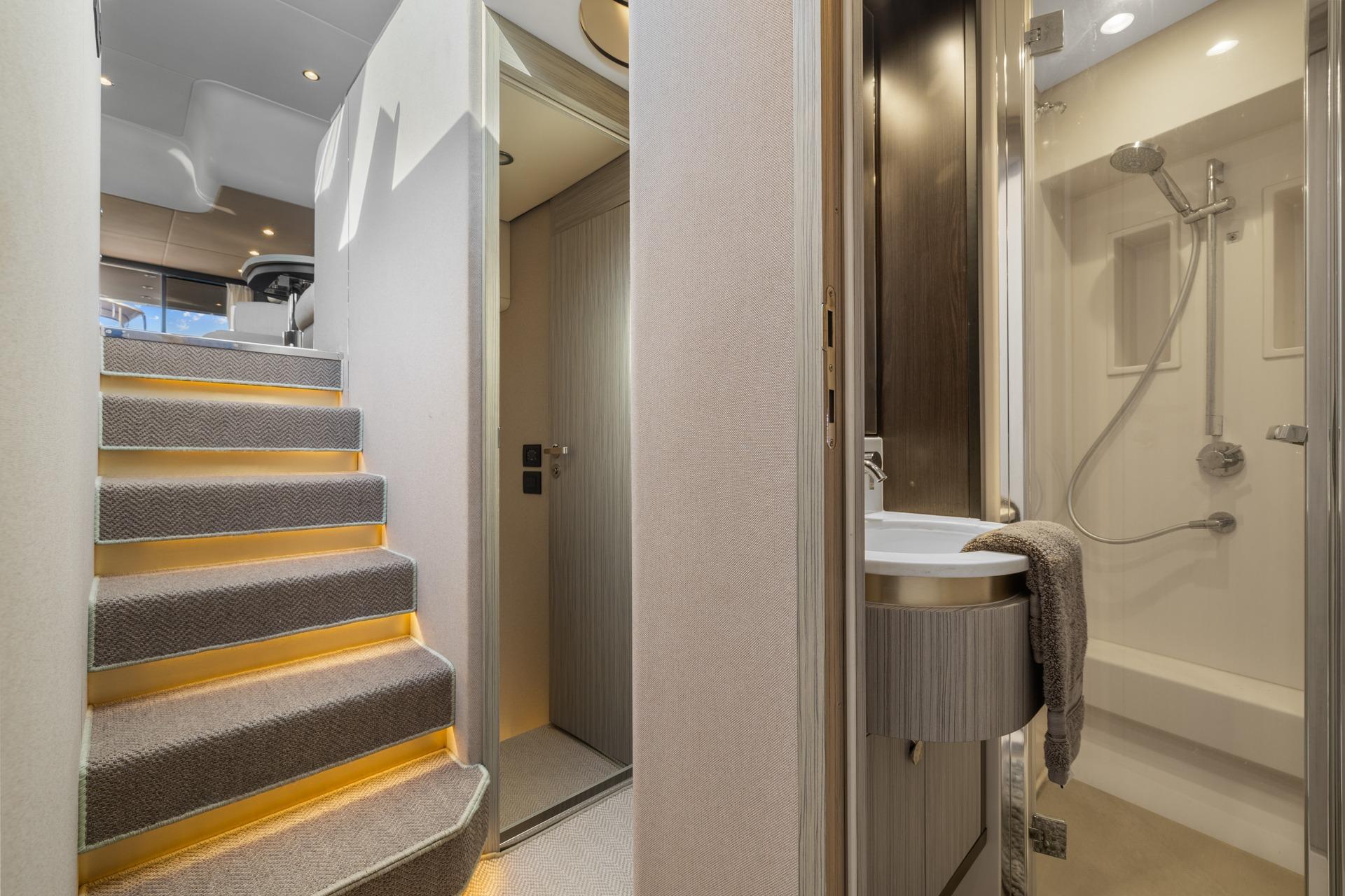 Luxurious interior of 2019 Azimut 55 yacht featuring staircase and modern bathroom.