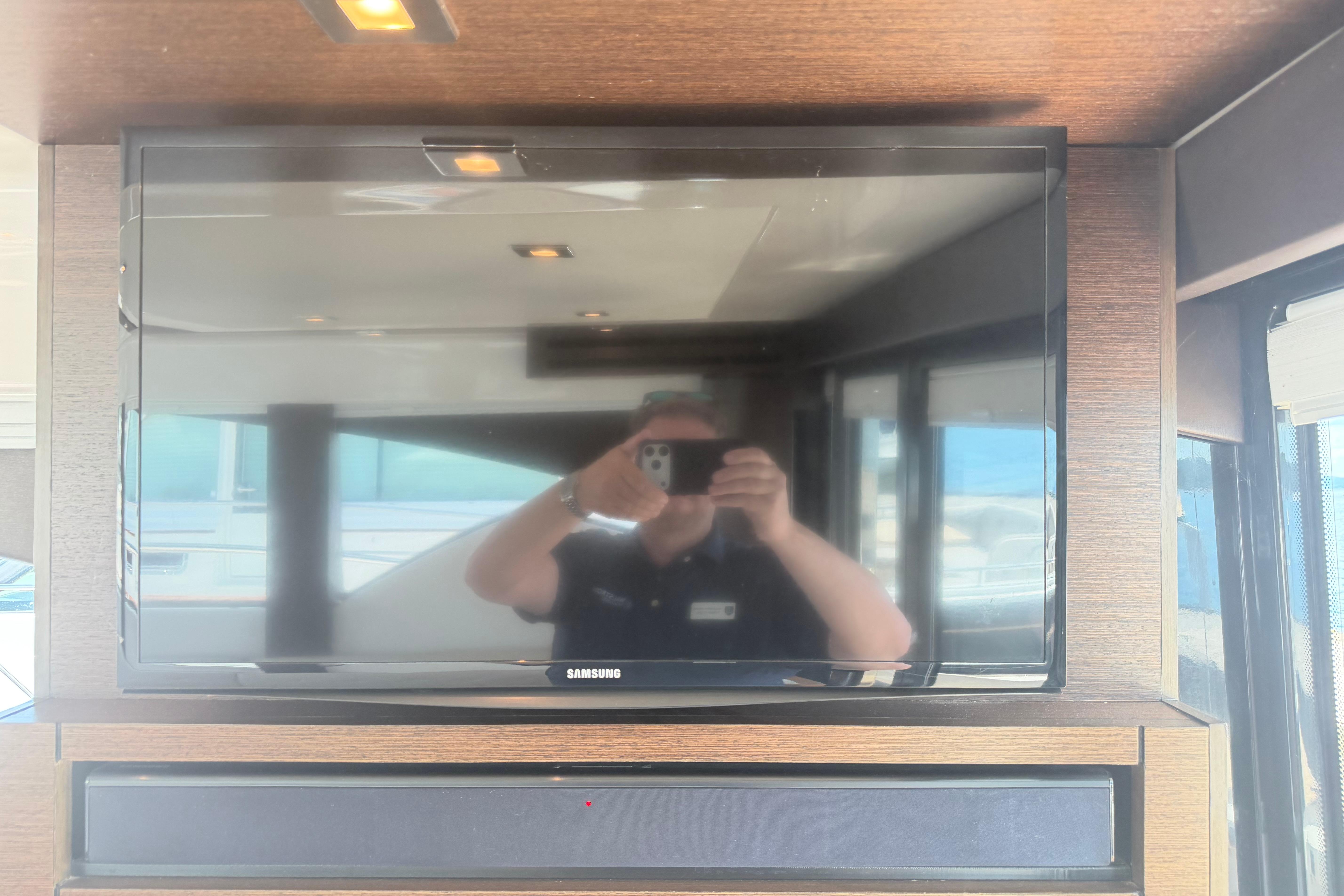 Samsung TV inside 2016 Tiara Yachts C39 Coupe, reflecting interior and person taking photo.