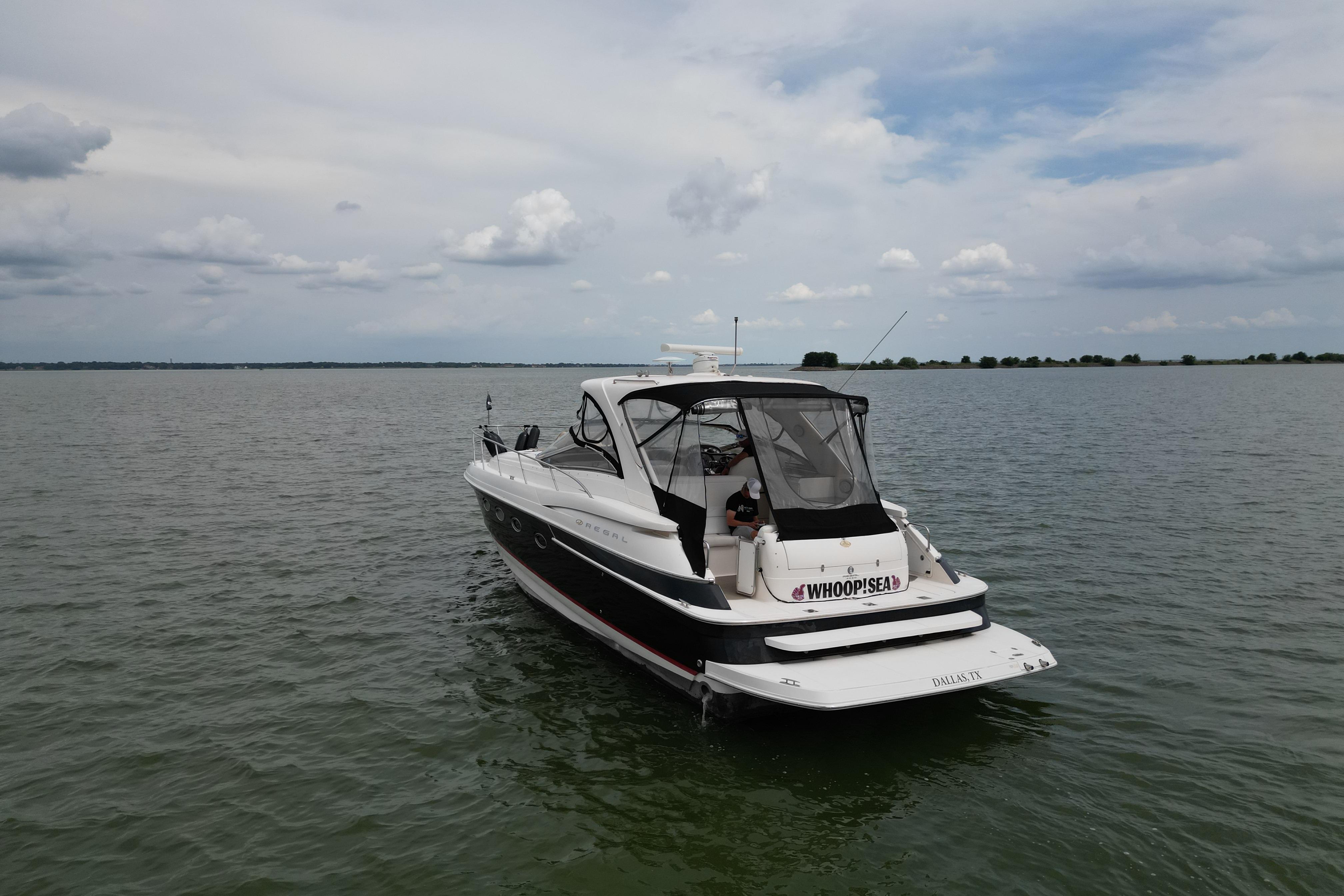 2005 Regal Commodore 4260 boat on calm water under cloudy sky.