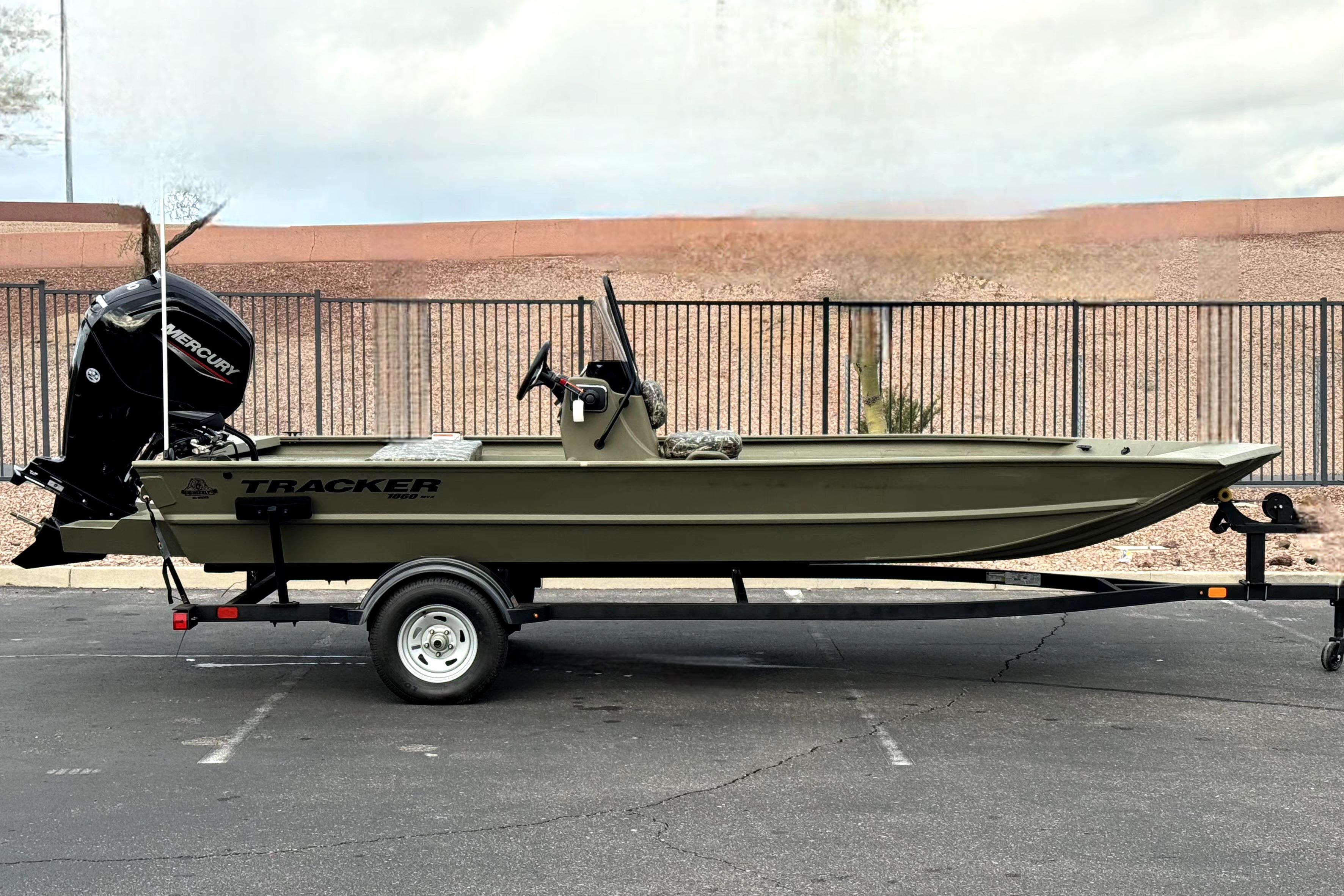 2025 Tracker Grizzly 1860 CC boat on trailer, side view, outdoors.