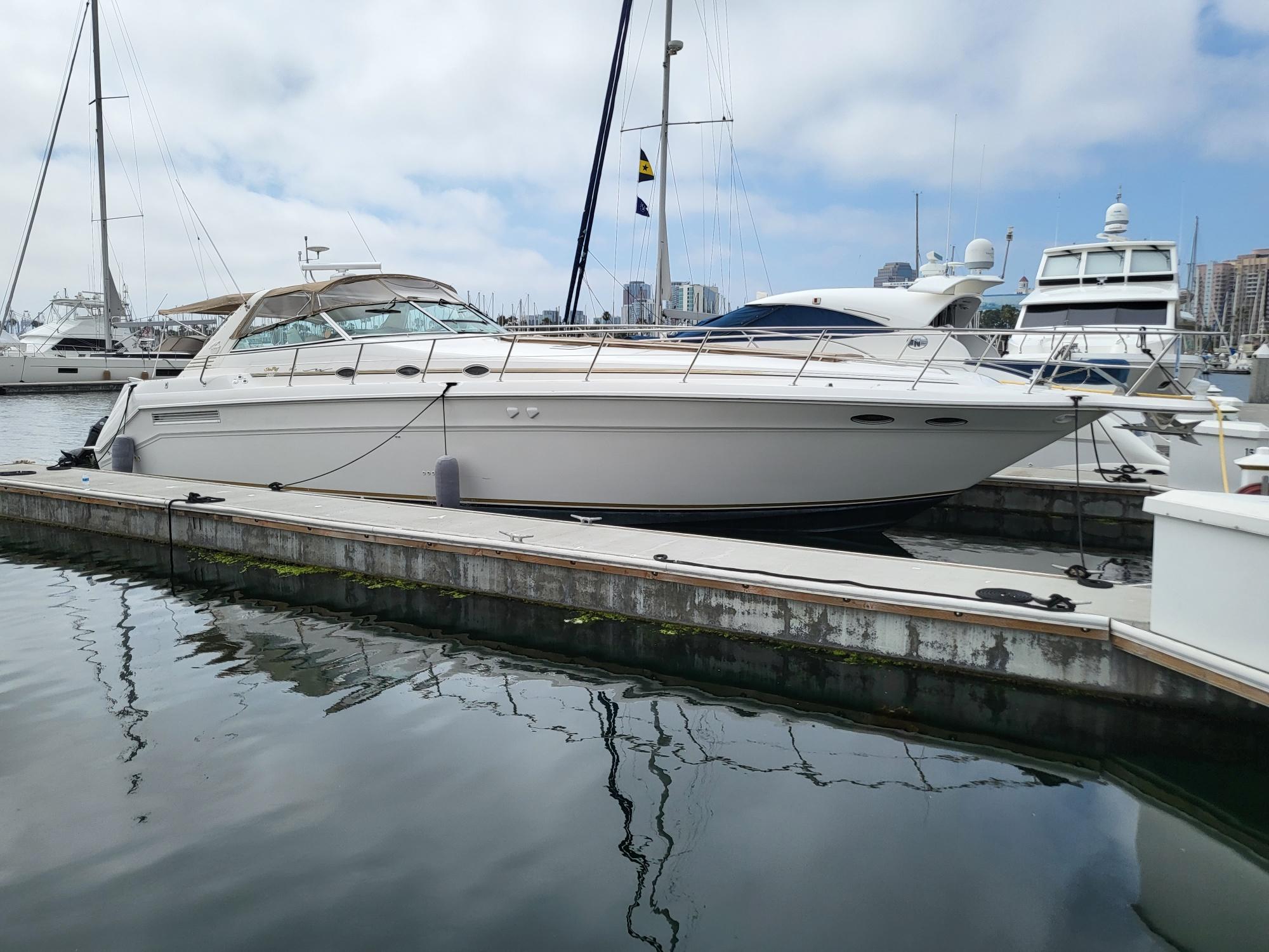 1996 Sea Ray 500 Sundancer yacht docked in a marina, surrounded by other boats.
