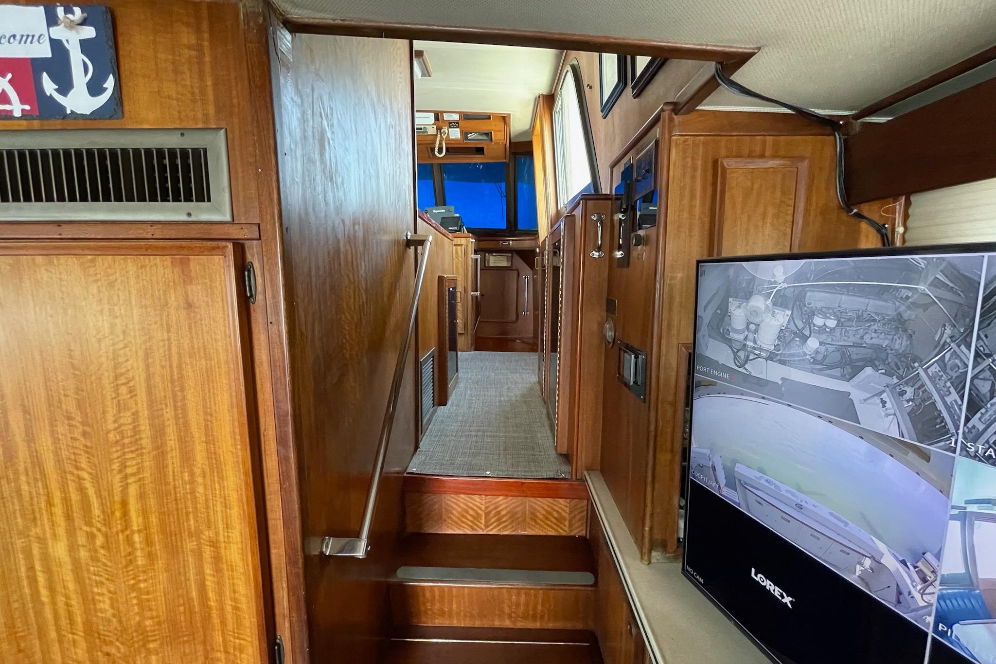 Interior of 1976 Hatteras 48 Long Range Cruiser with wood paneling and security monitor.