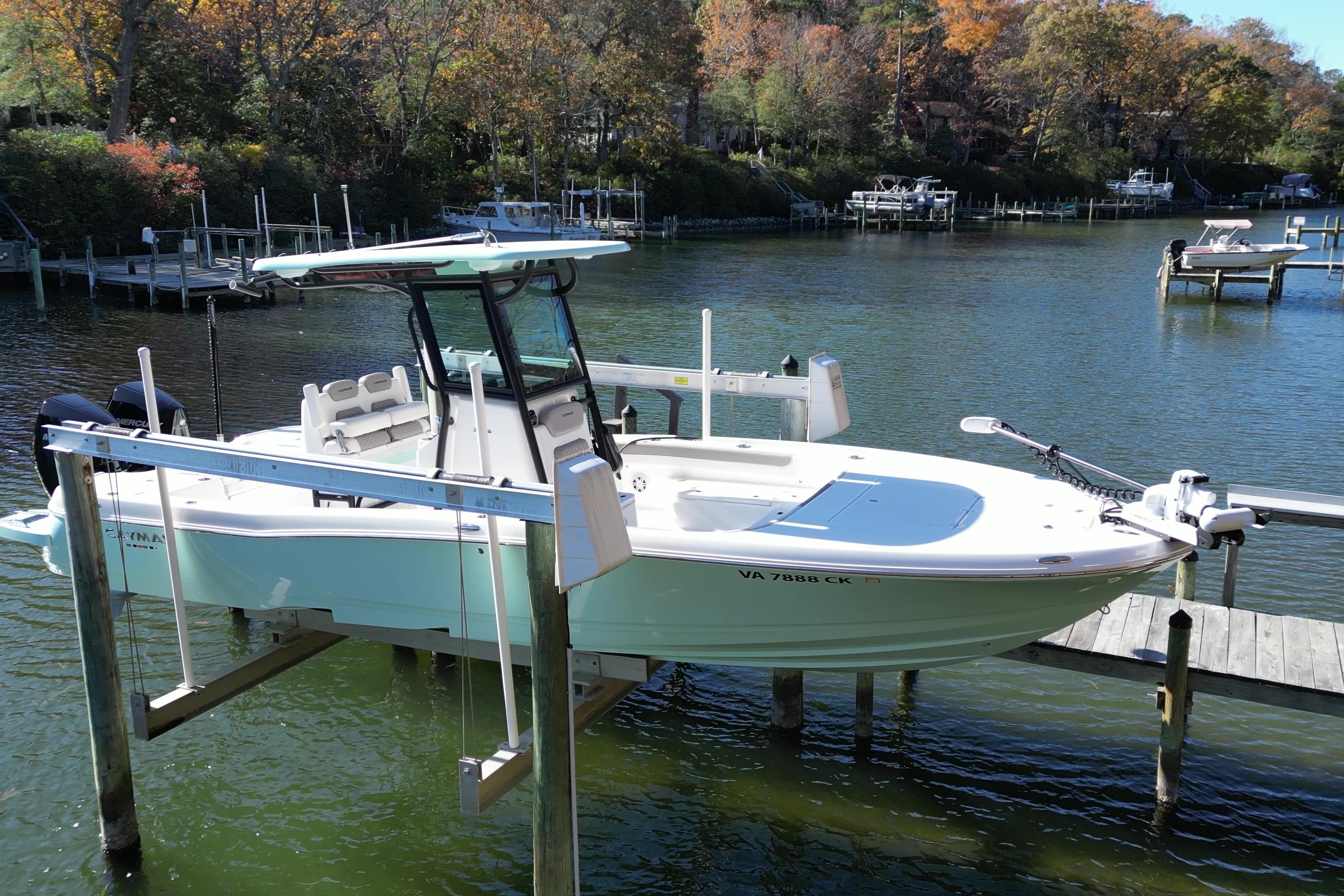 2023 Caymas 281 HB boat docked on a serene lake with autumn foliage.