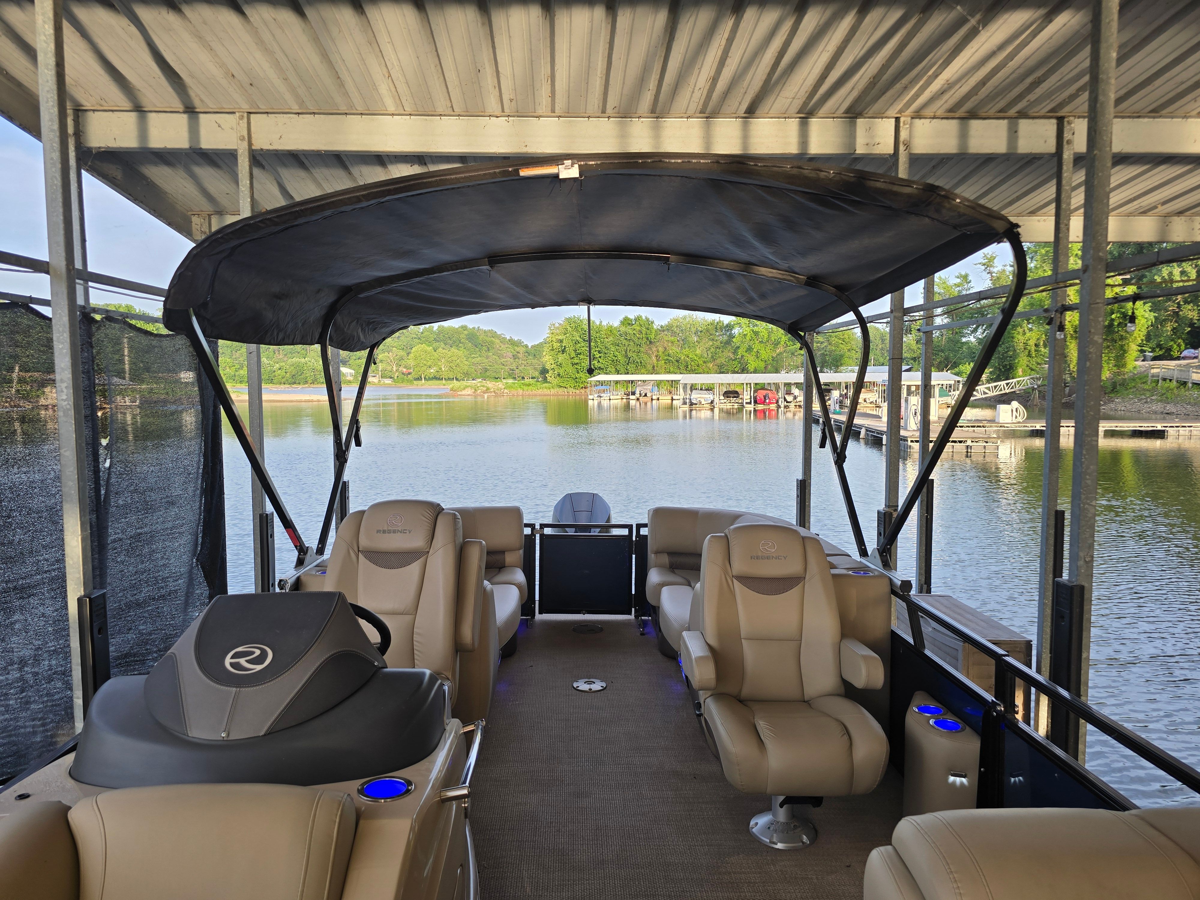 The image shows the interior of a 2021 Regency 230 LE3 pontoon boat docked at a marina.