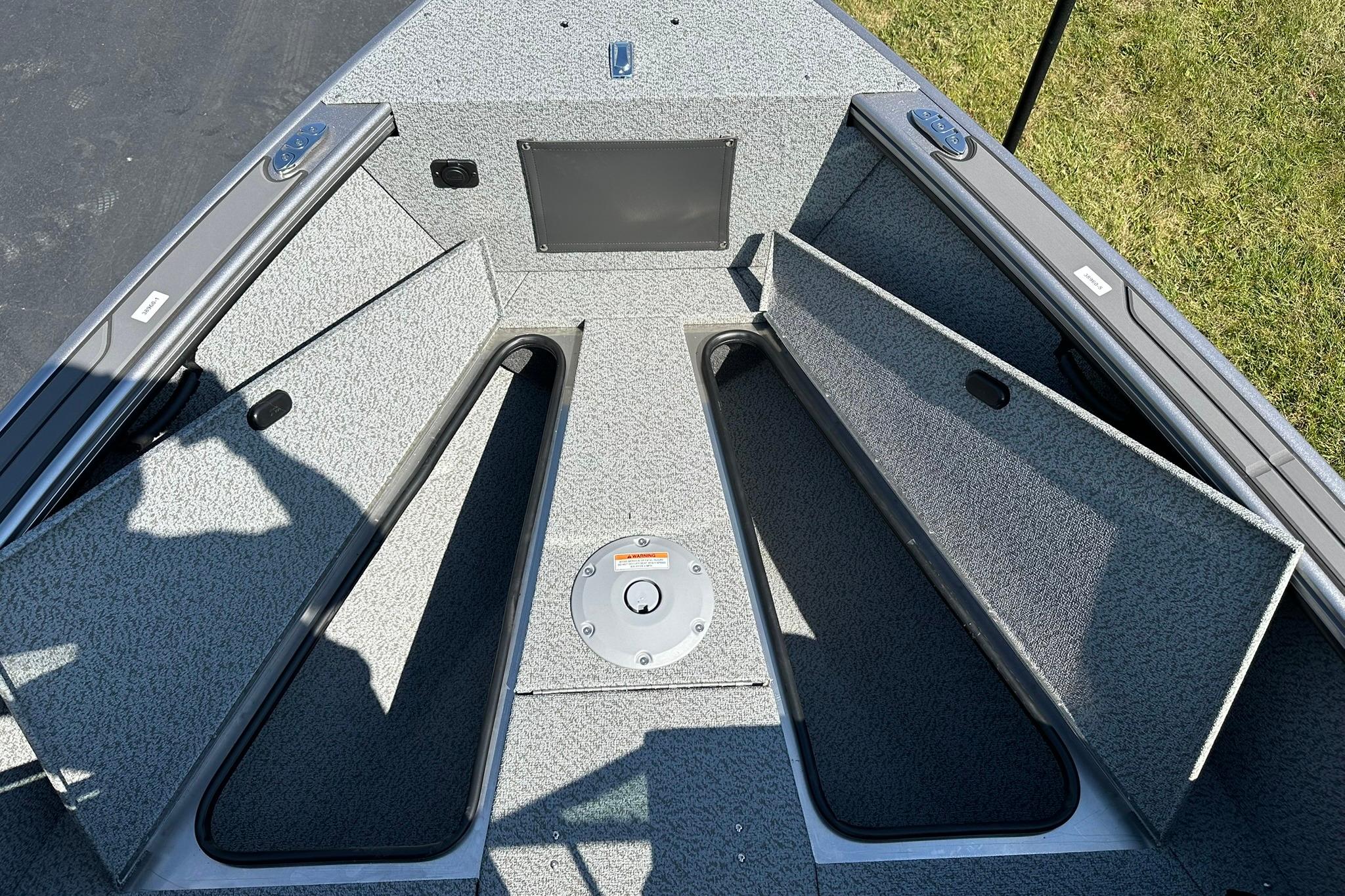 2026 Lund 1875 Fisherman boat interior with open storage compartments and textured flooring.