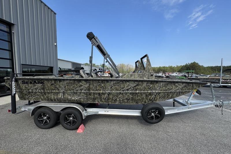 2025 SeaArk Predator 300 AK boat on trailer, camo design, parked outdoors.