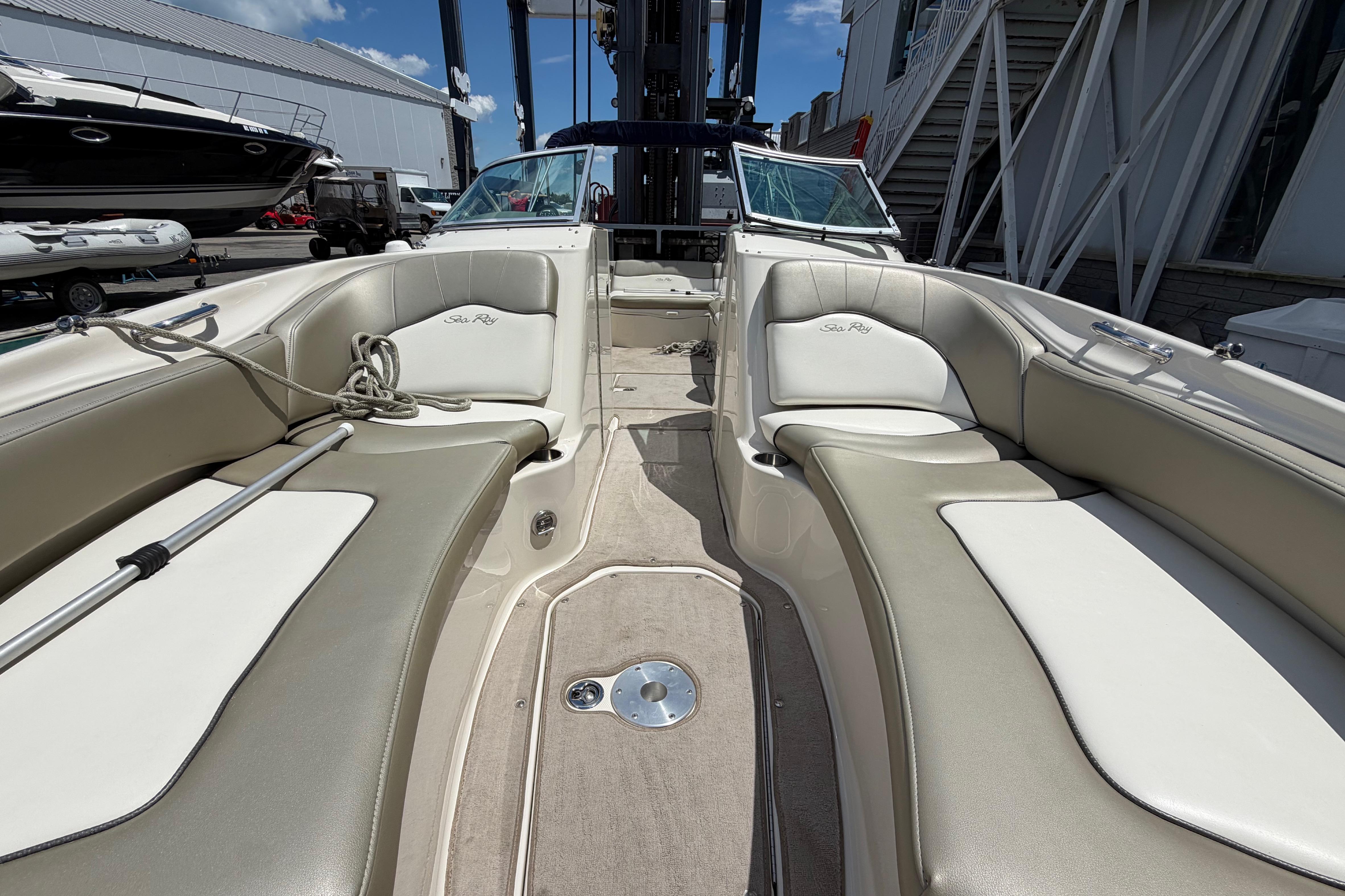2004 Sea Ray 240 Sundeck interior with beige seating and open deck layout.